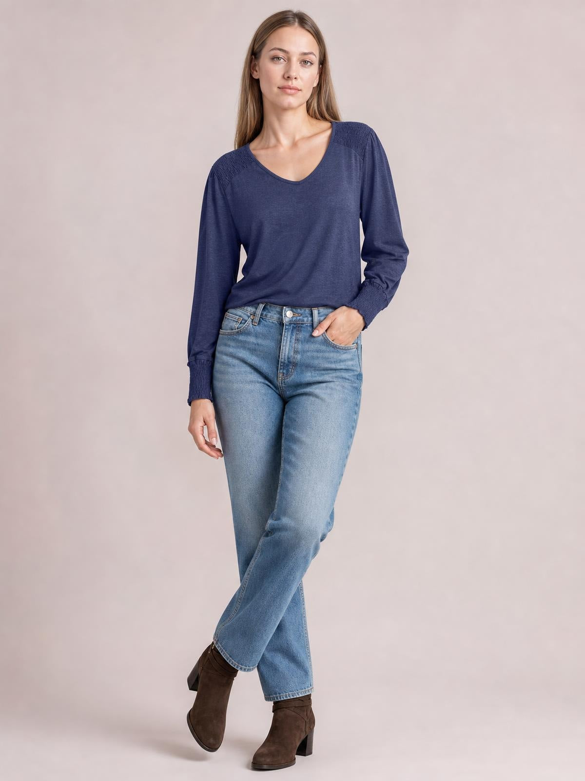Model poses in a navy V-neck lantern sleeve T-shirt with a relaxed silhouette, gathered shoulder details, and elasticized cuffs.