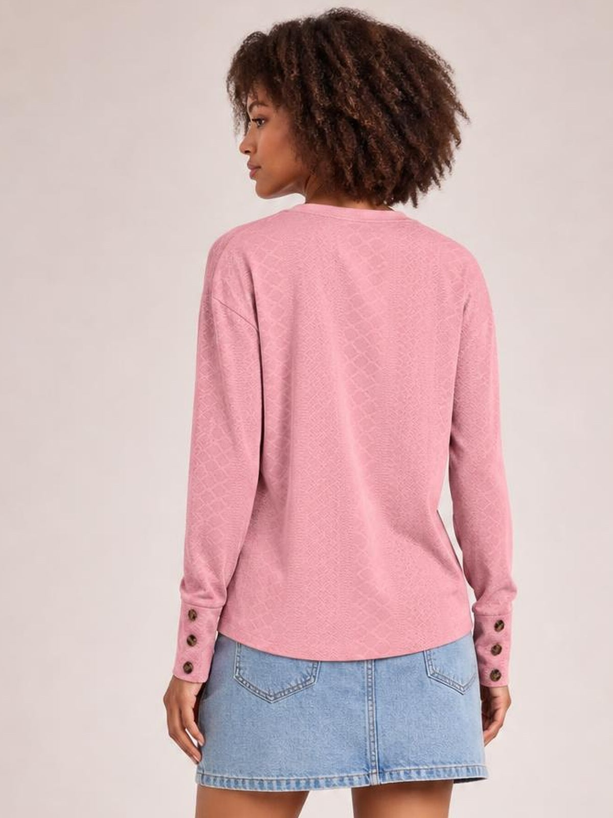 Model shown from the back wearing a pink long-sleeve blouse with a relaxed regular silhouette, straight hem, and buttoned cuffs.