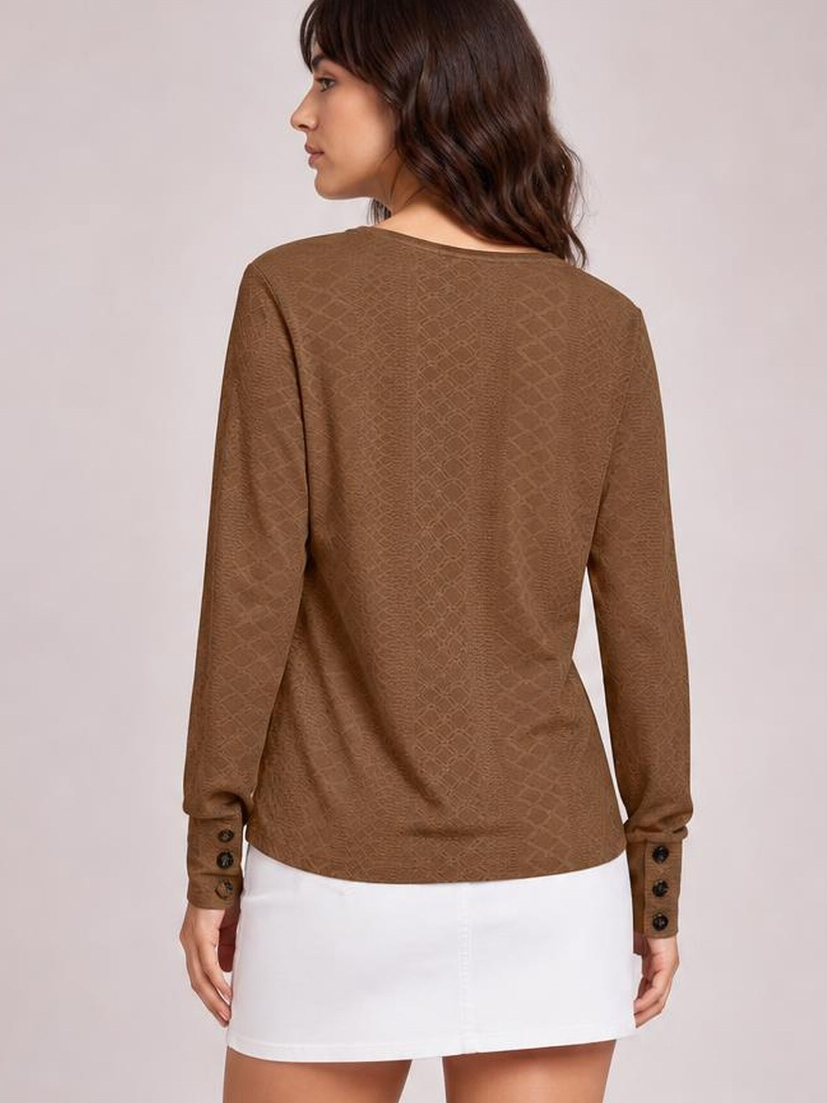 Model shown from the back wearing a brown long-sleeve blouse with a regular silhouette, subtle tonal texture, and buttoned cuffs.