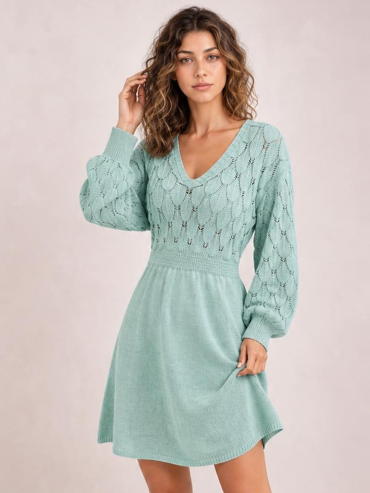 Model wearing a mint green V-neck long sleeve sweater dress with openwork knit bodice, ribbed cuffs and waist, and a softly flared silhouette.