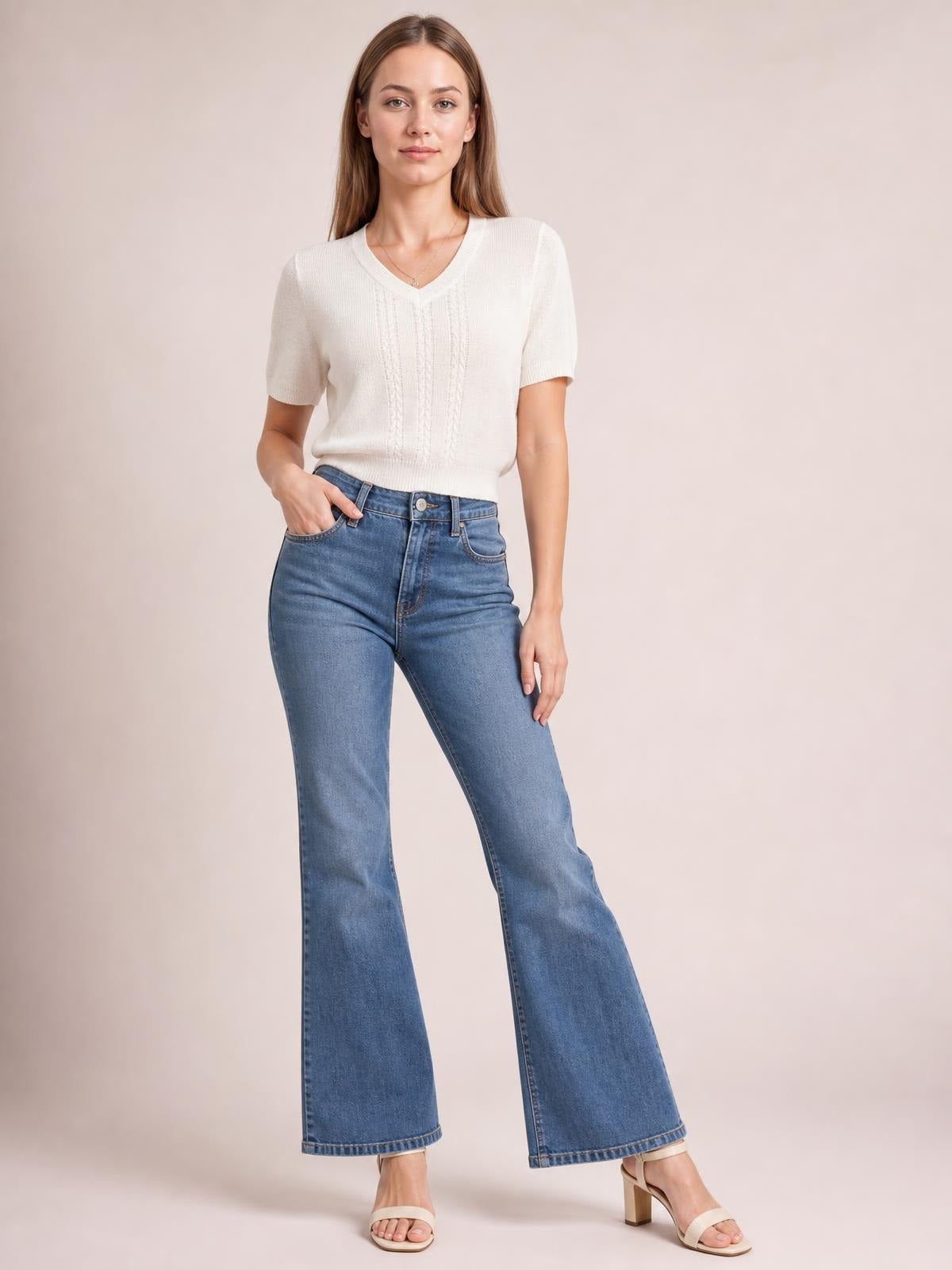 Model wearing an ivory V-neck short sleeve knit top with a straight silhouette, ribbed trim, and subtle vertical textured knit panels.