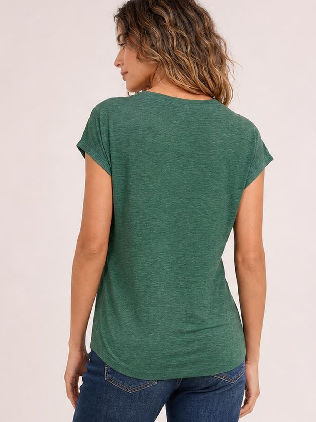 Model shown from the back in a heathered green short-sleeve T-shirt with a relaxed silhouette, curved hem, and simple everyday construction.