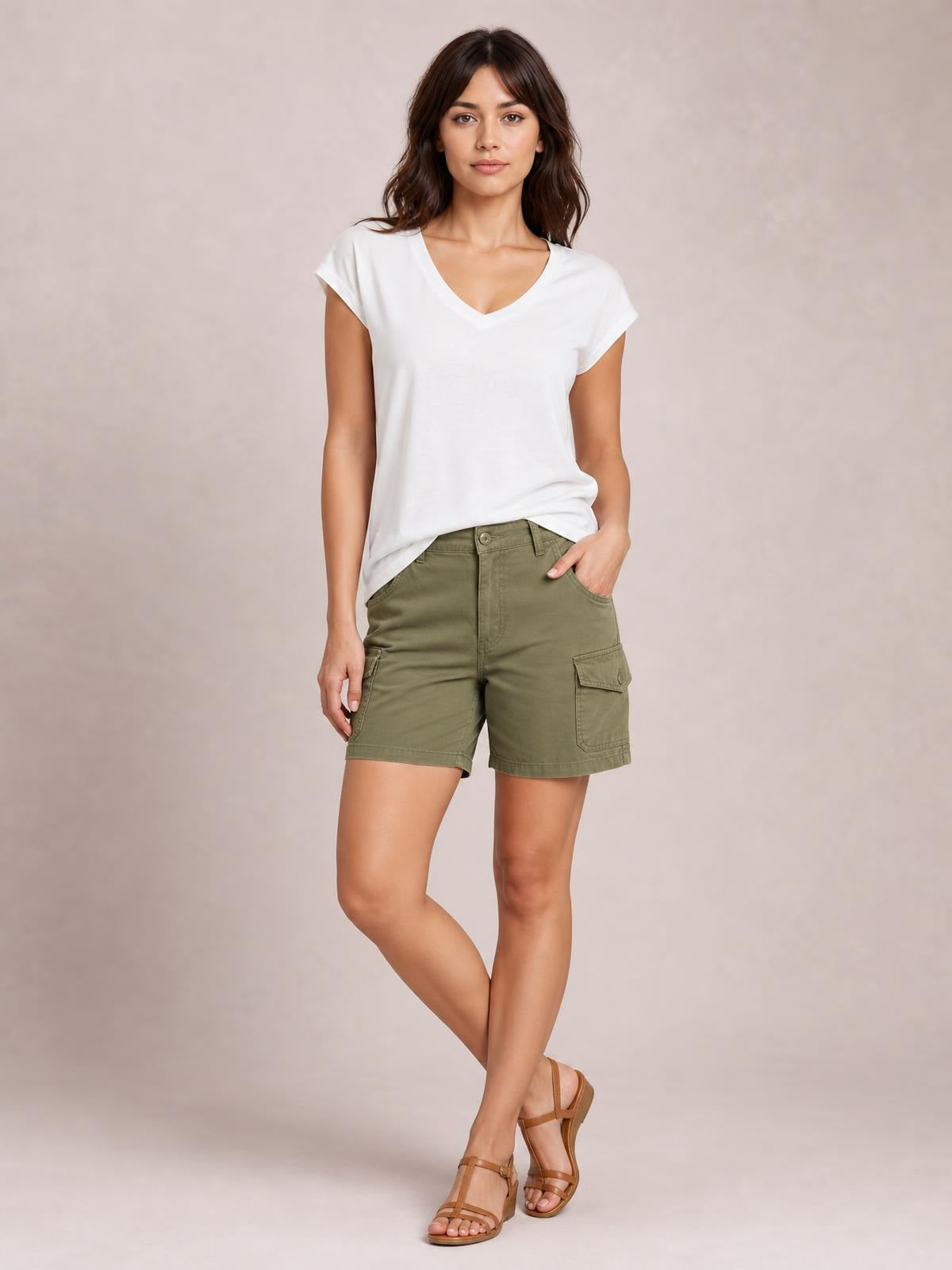 Model poses in a white V-neck short sleeve T-shirt with a relaxed straight silhouette and folded sleeve cuffs.