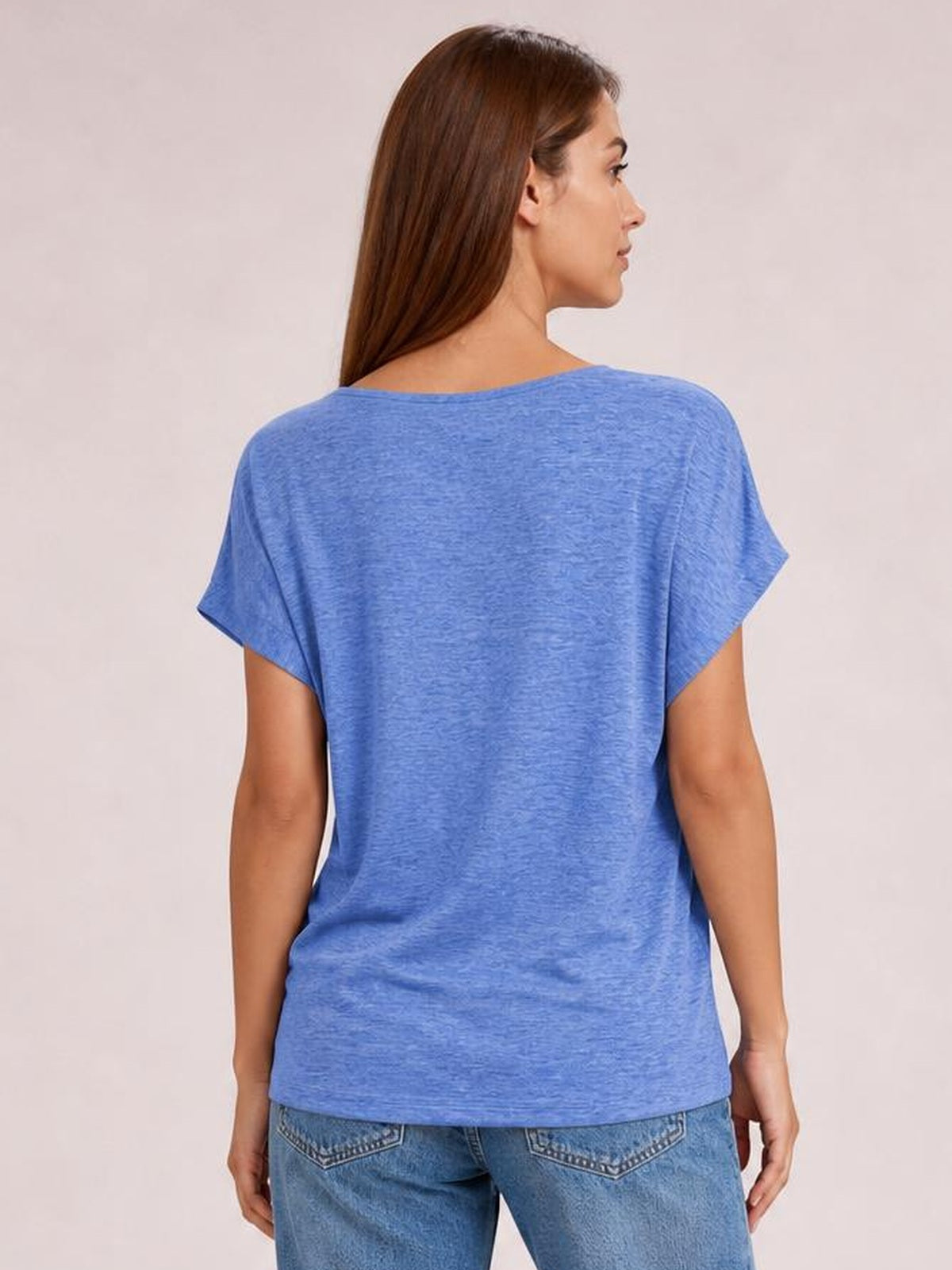 A model is shown from the back wearing a blue short-sleeve T-shirt with a relaxed, straight silhouette and softly textured fabric.
