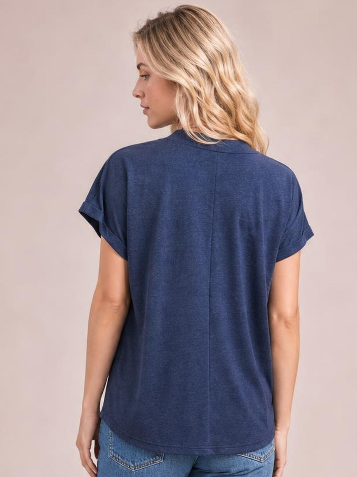 Model shown from the back in a navy short-sleeve T-shirt with rolled cuffs, relaxed straight silhouette, center-back seam, and curved hem.