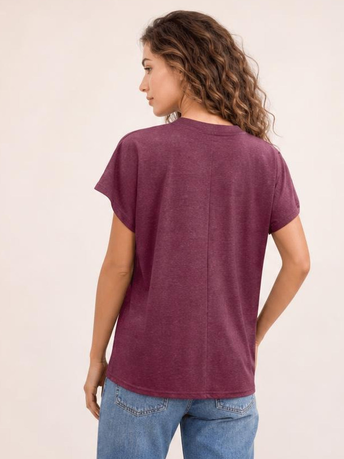 A model wears a burgundy short-sleeve T-shirt shown from the back, featuring a relaxed straight silhouette, smooth opaque fabric, and a center-back seam.