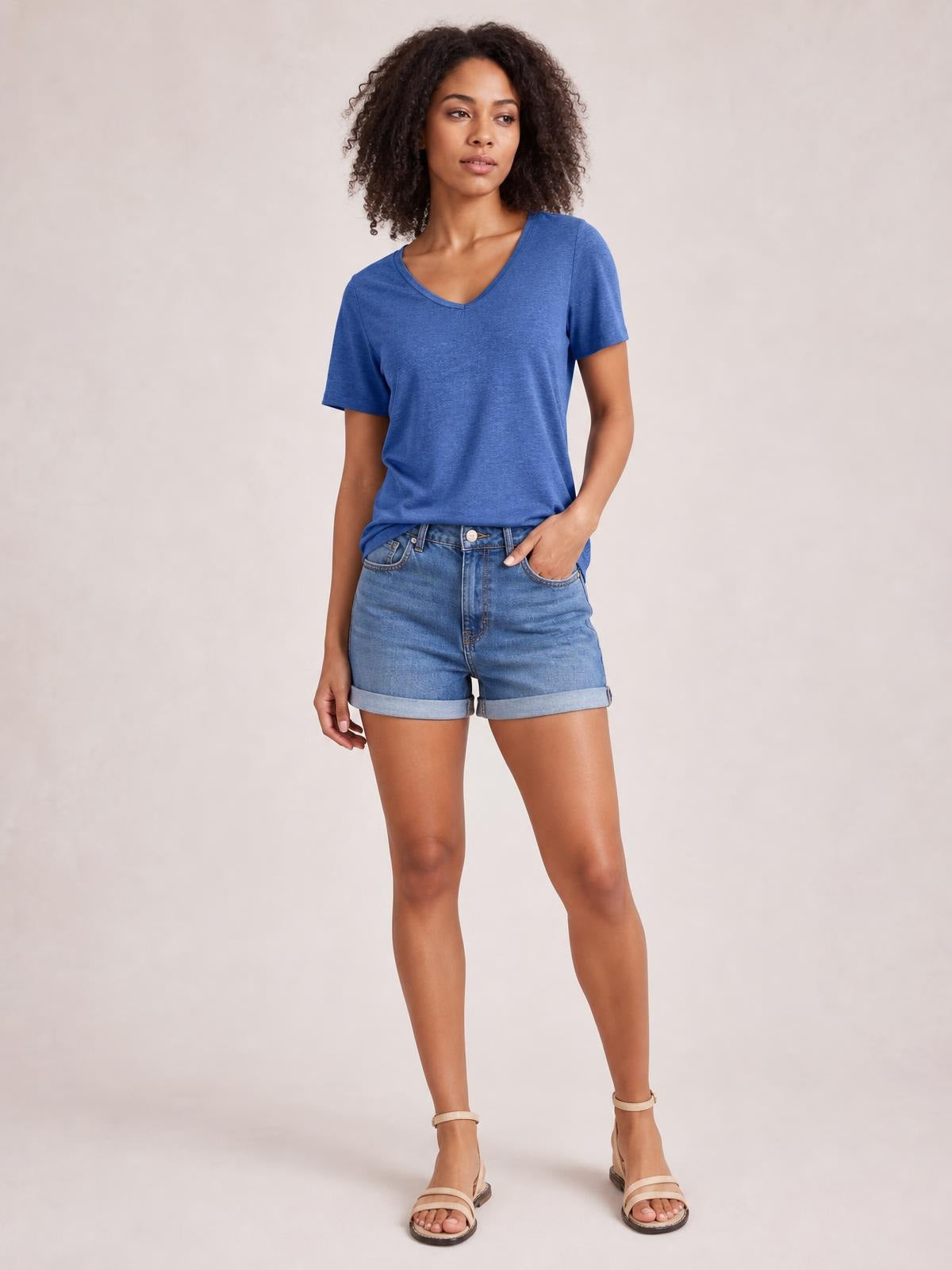 Model wearing a blue V-neck short sleeve T-shirt with a relaxed silhouette, subtle stretch, and clean neckline and sleeve construction.