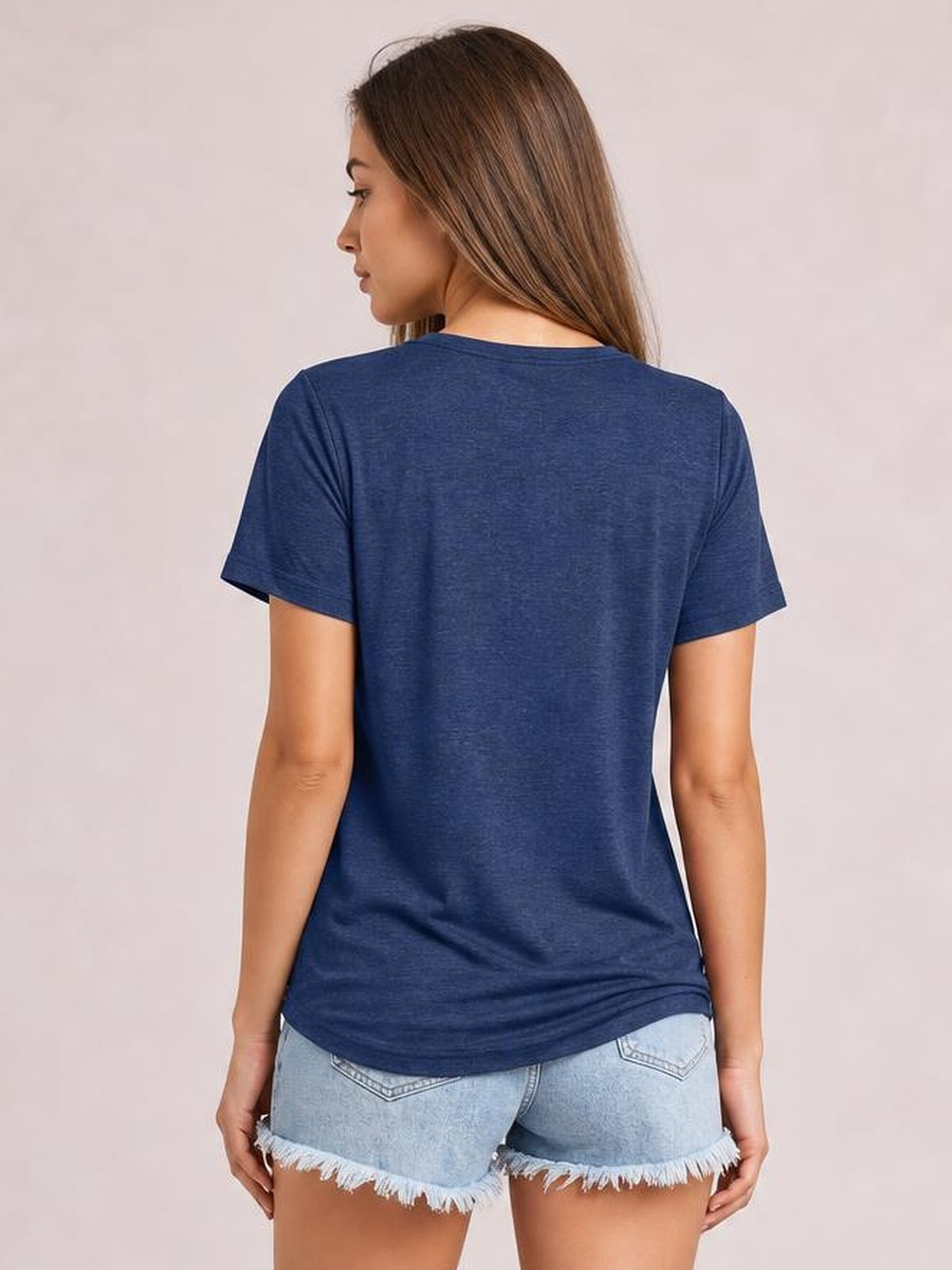 Model shown from behind wearing a navy short-sleeve T-shirt with a relaxed straight silhouette, smooth opaque fabric, and a curved hem.