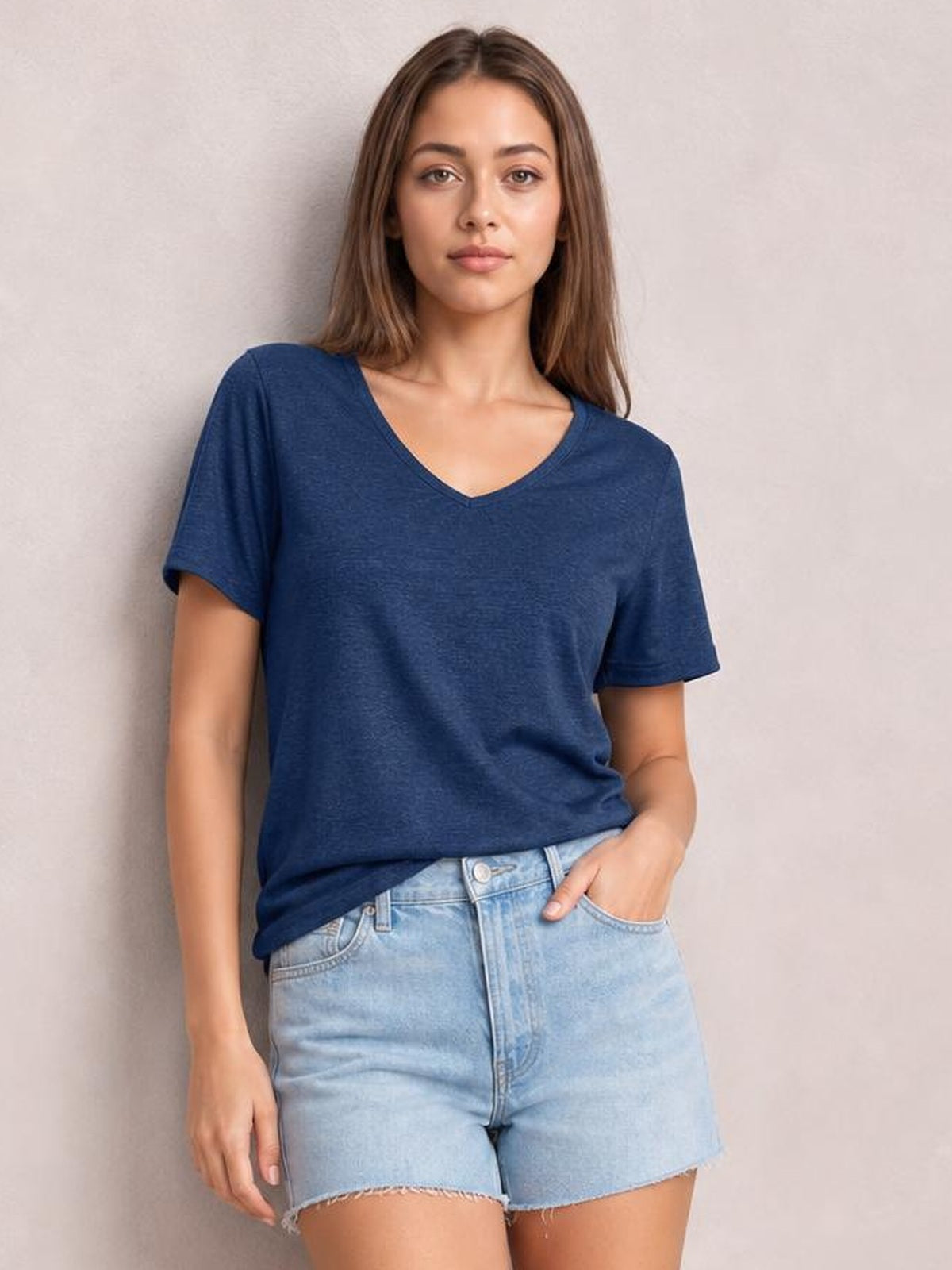 Model wearing a navy blue V-neck short sleeve T-shirt with a relaxed silhouette, slightly stretchy fabric, and a casually untucked hem.
