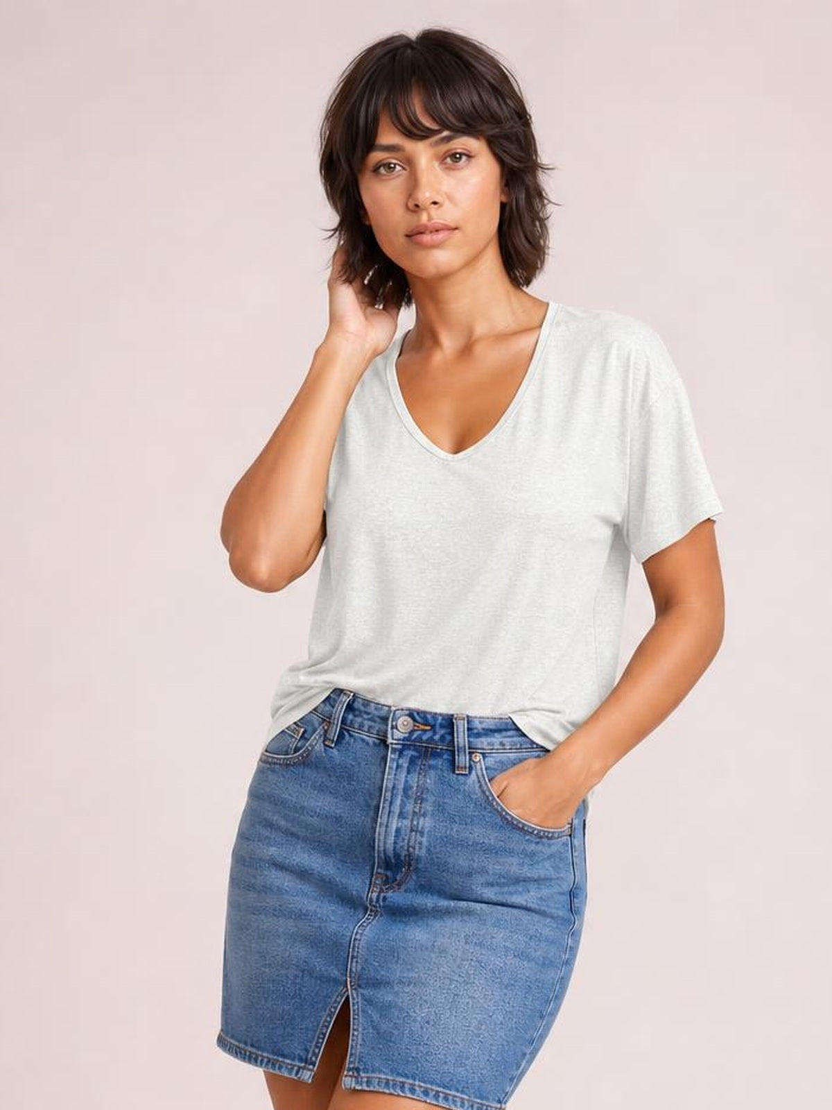 A model wears a light gray V-neck short sleeve T-shirt with a relaxed silhouette, finished with a seamed neckline and straight hem.