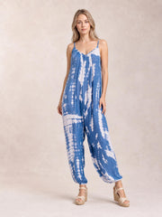 A model stands in a blue-and-white tie-dye V-neck spaghetti strap jumpsuit with a relaxed wide-leg silhouette and elasticized ankle cuffs.