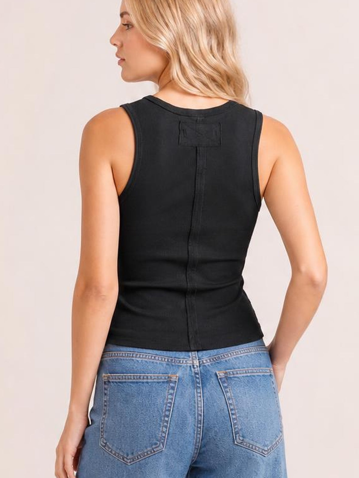 Model shown from behind wears a black wide-strap tank with a fitted silhouette, sleeveless cut, and center-back seam.