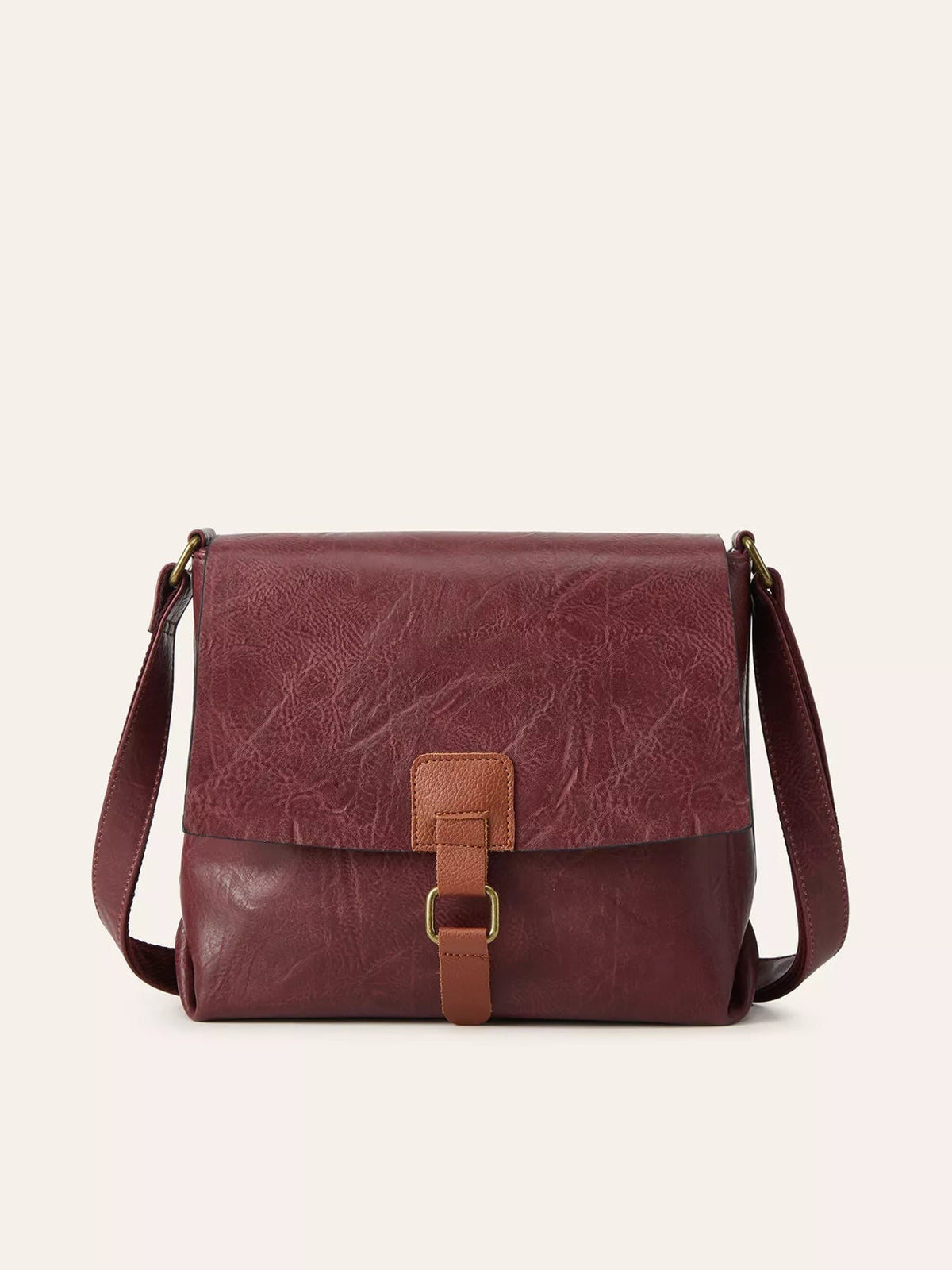 Medium burgundy PU leather crossbody bag with a vintage flap design, textured finish, adjustable strap, and central buckle closure.