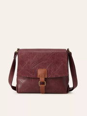 Medium burgundy PU leather crossbody bag with a vintage flap design, textured finish, adjustable strap, and central buckle closure.