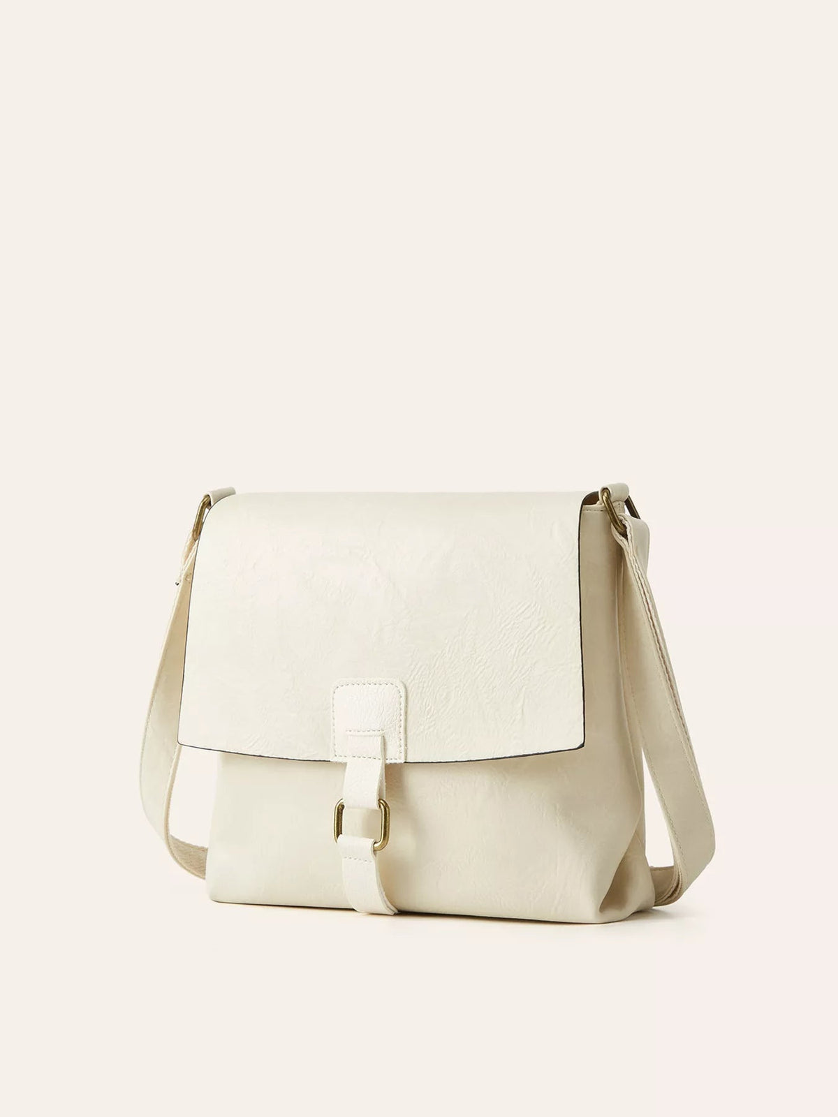 A medium ivory PU leather crossbody bag with a structured flap, vintage buckle closure, adjustable strap, and softly rounded silhouette.