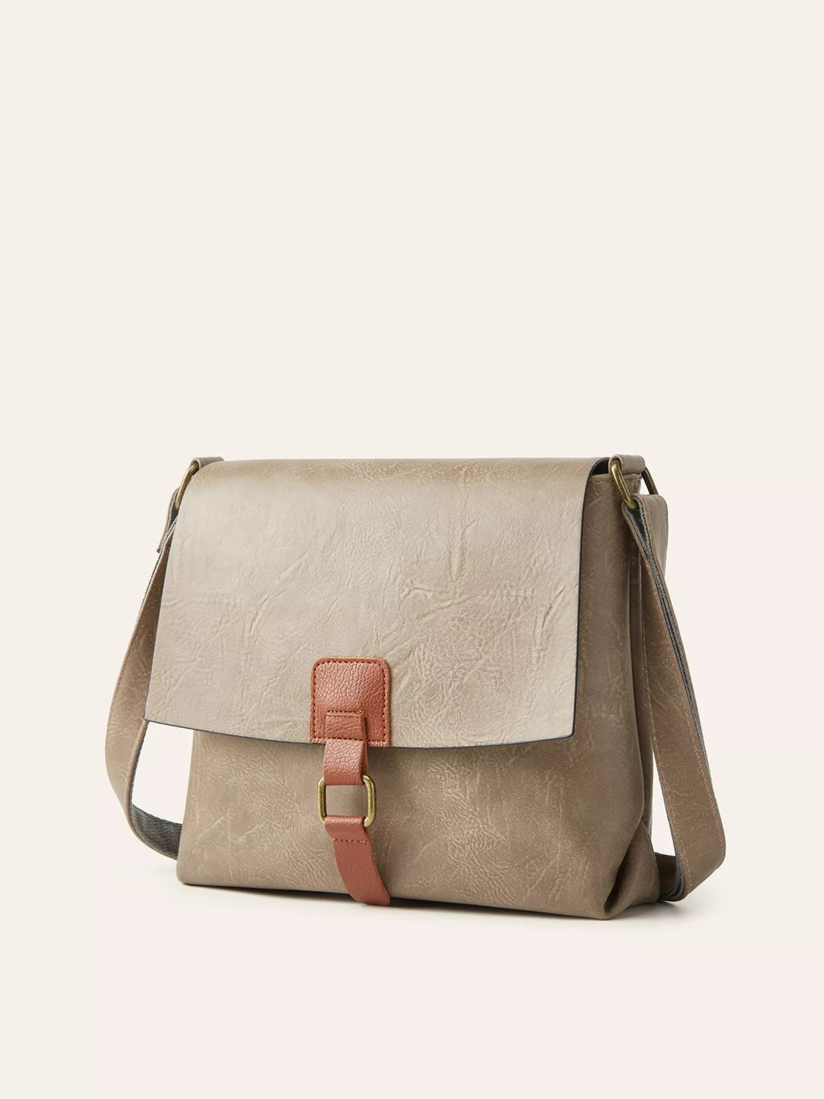 A medium taupe PU leather crossbody bag with a structured silhouette, flap closure, brown buckle strap, and long shoulder strap.