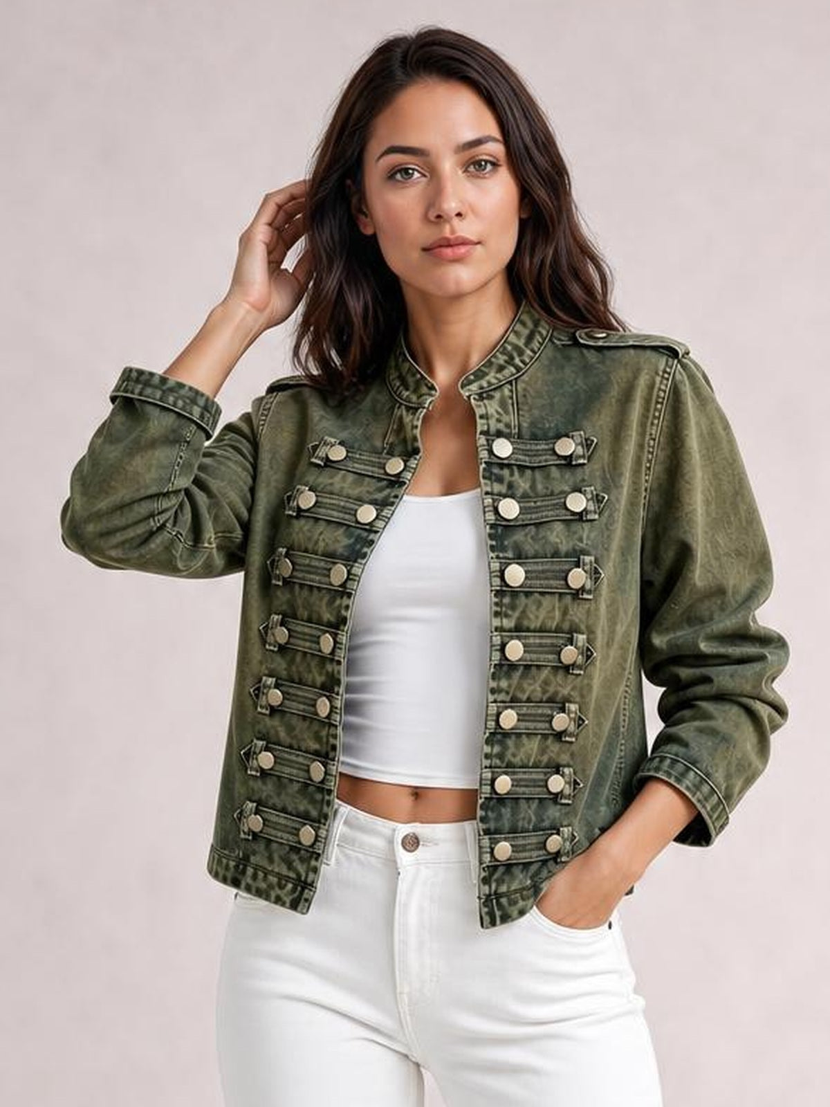 A woman poses in a washed olive-green vintage denim jacket with an open front, stand collar, epaulets, long sleeves, and decorative buttoned tabs.
