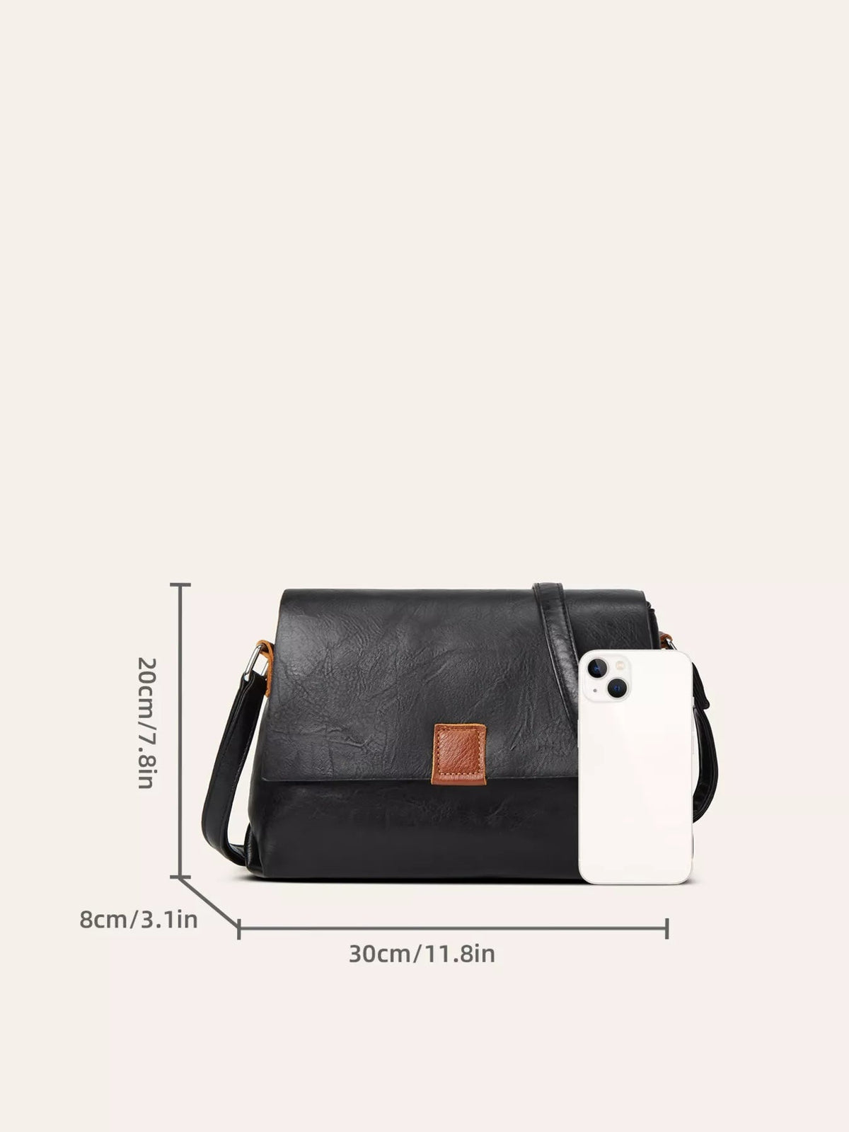 A medium black PU leather crossbody bag features a structured silhouette, flap closure, adjustable shoulder strap, and brown front tab.