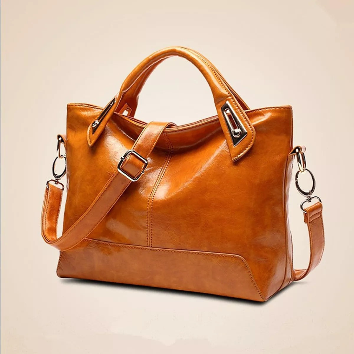 Medium vintage-style cognac PU leather tote handbag with structured silhouette, twin top handles, stitched panels, metal hardware, and an adjustable shoulder strap.