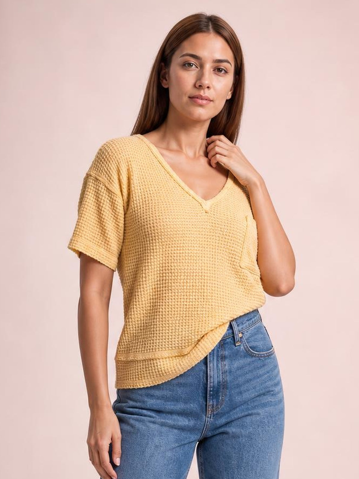 Model wears a mustard waffle-knit t-shirt with a notched V-neck, relaxed half sleeves, straight silhouette, and subtle chest pocket, touching the neckline.