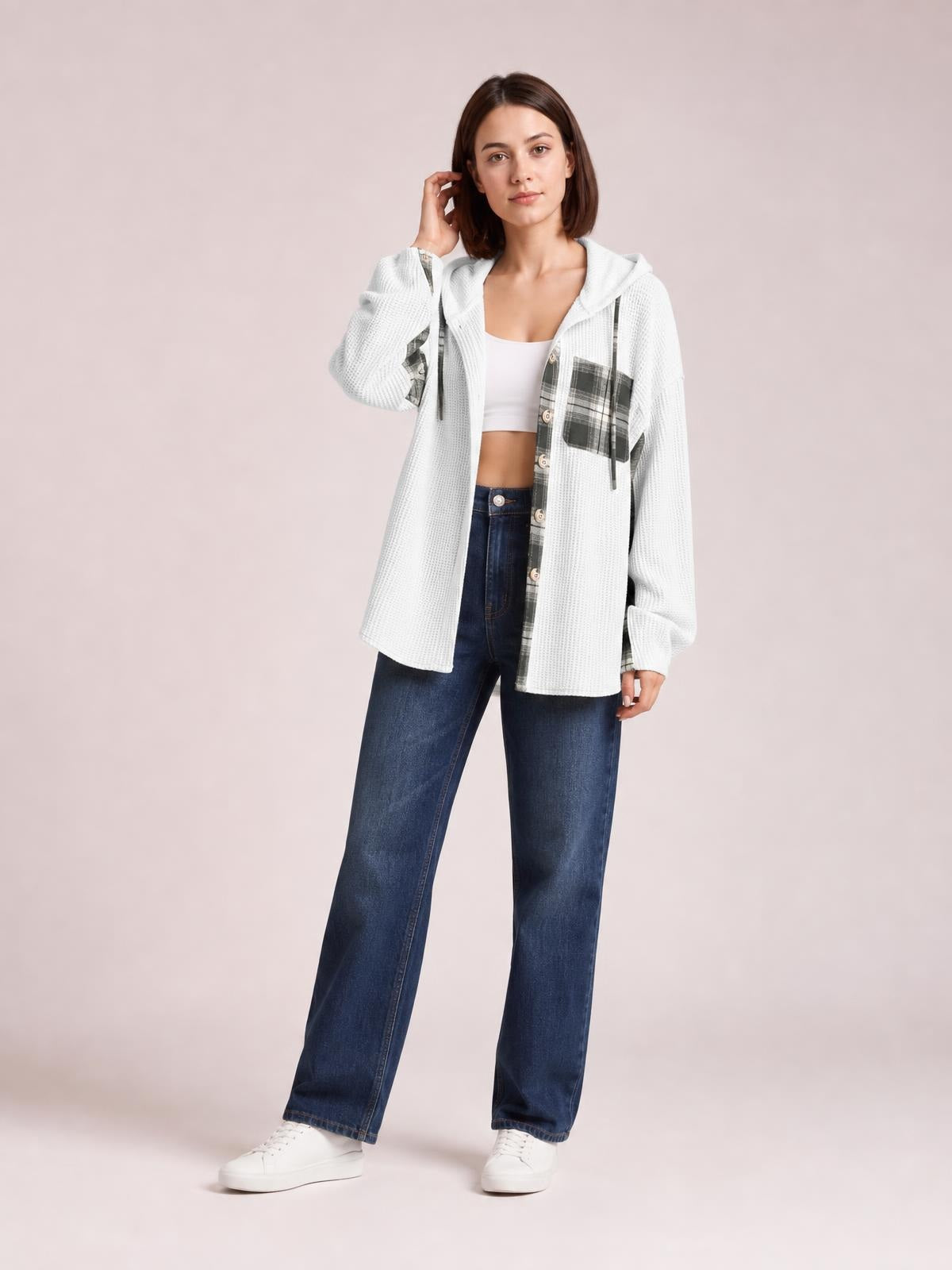 Model wears a relaxed white waffle knit plaid patchwork hooded shacket with drawstrings, button front, pockets, and a long shirt silhouette.