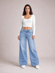 Model stands facing forward in light blue washed wide leg jeans with front and back pockets, belt loops, button fly, and a relaxed full-length silhouette.