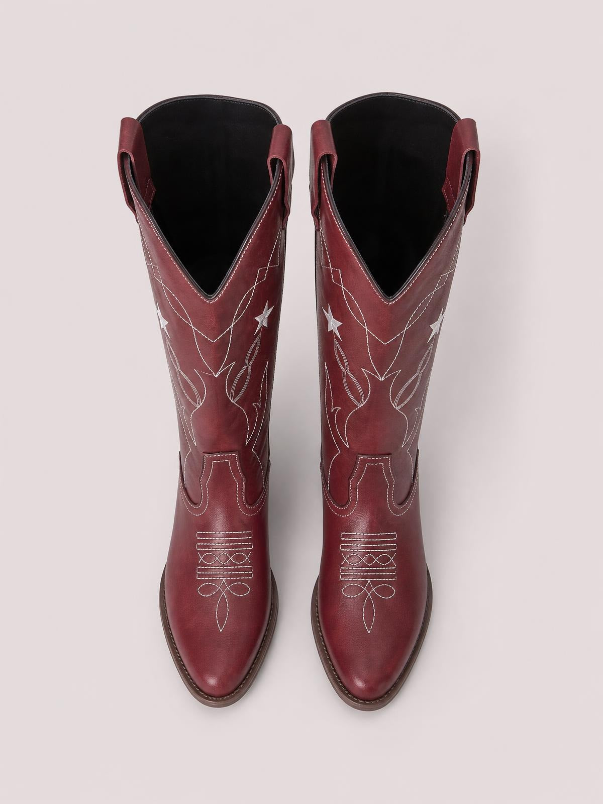 Burgundy Western Star cowboy boots feature pointed toes, low heels, pull tabs, and white embroidered star and geometric stitching on the shafts.