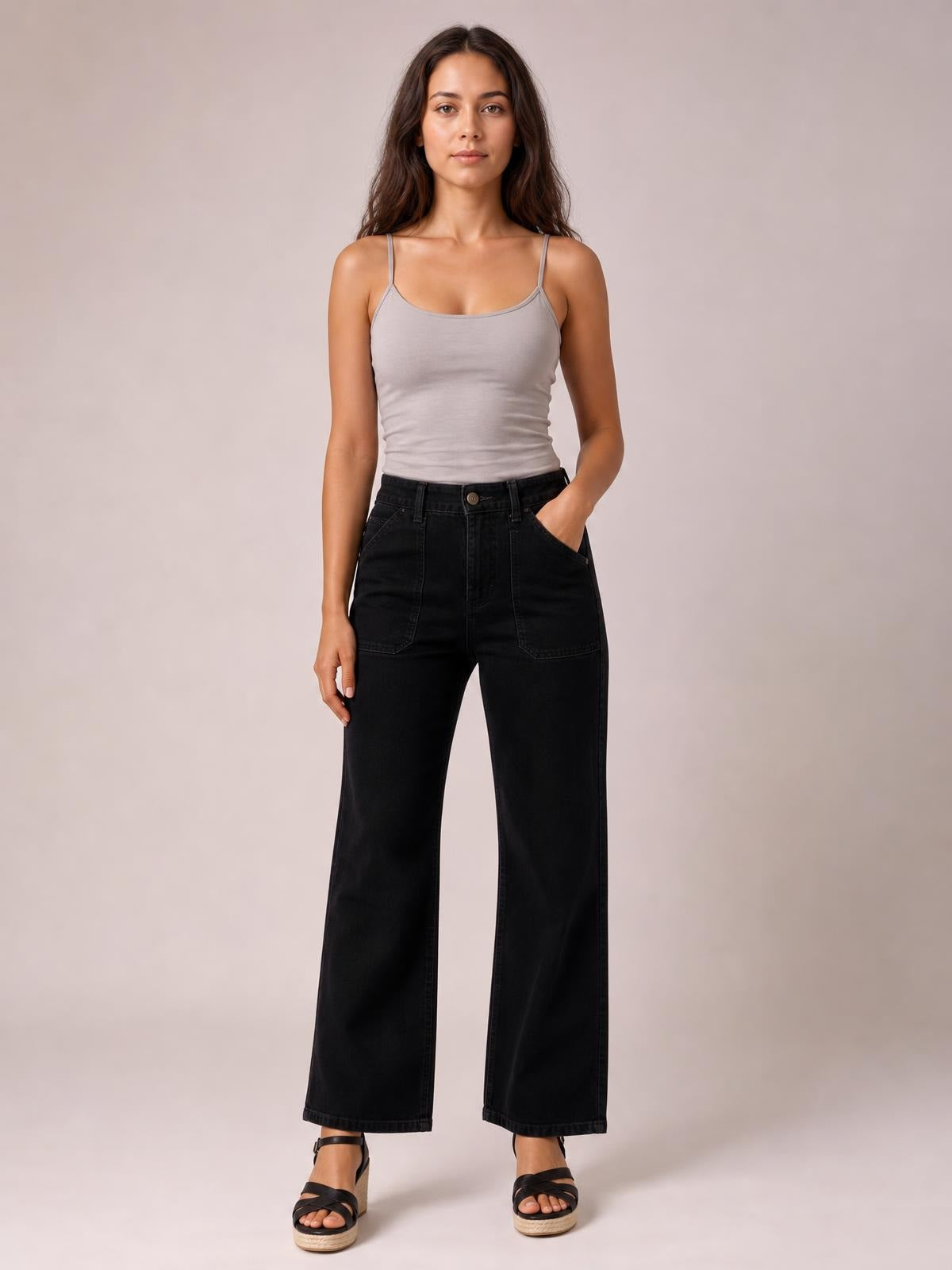 A model stands in black wide-leg jeans with contrasting stitching, a high waist, belt loops, front pockets, and straight, relaxed legs.
