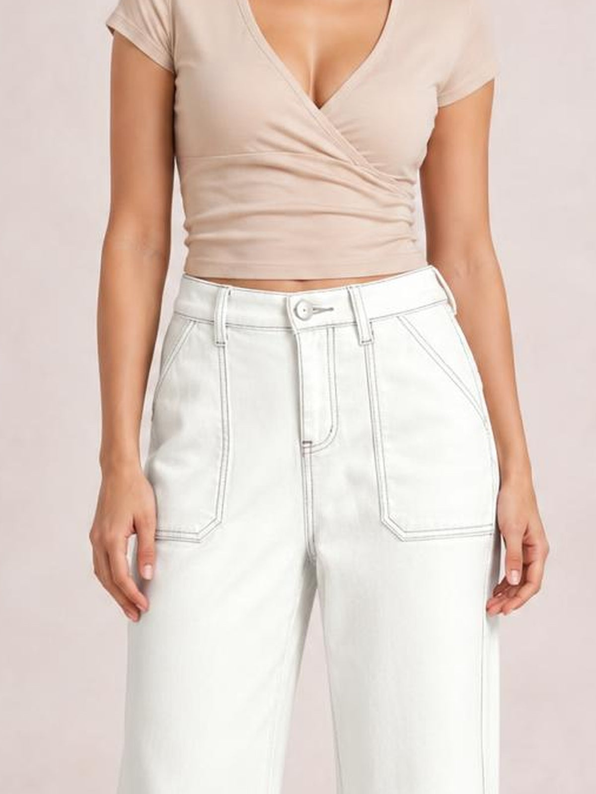 Model stands wearing white wide-leg contrast stitching jeans with belt loops, button closure, front pockets, and visible seam detailing.