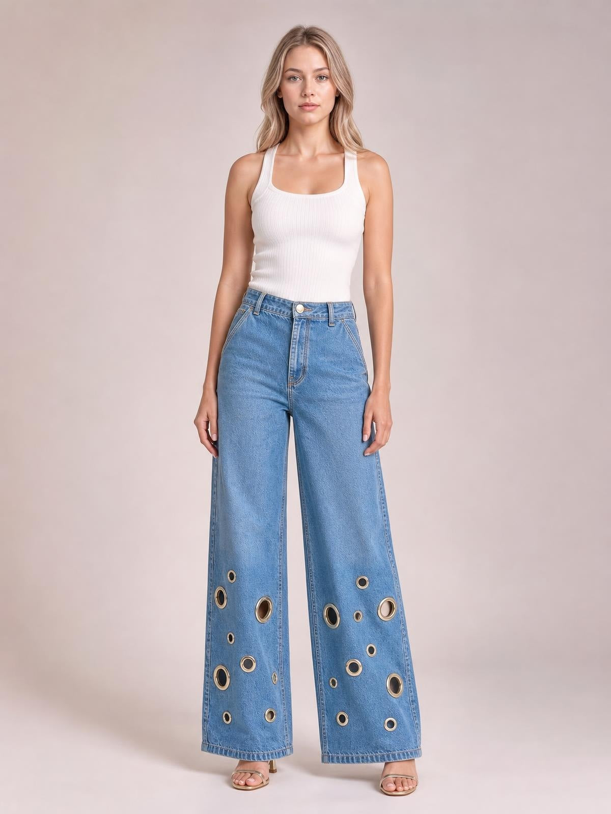 Model wears light blue wide leg jeans with a high waist, front fly, belt loops, and multiple metallic eyelet details along the lower legs.