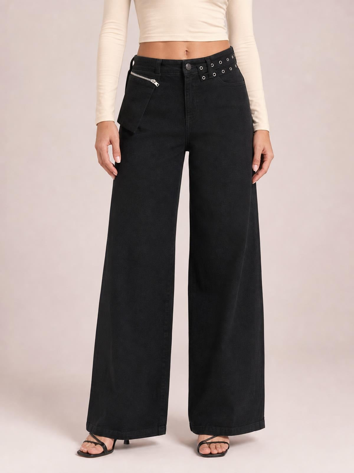 A standing model wears black wide-leg jeans with front pockets, a zippered pocket, belt loops, and a full-length relaxed silhouette.