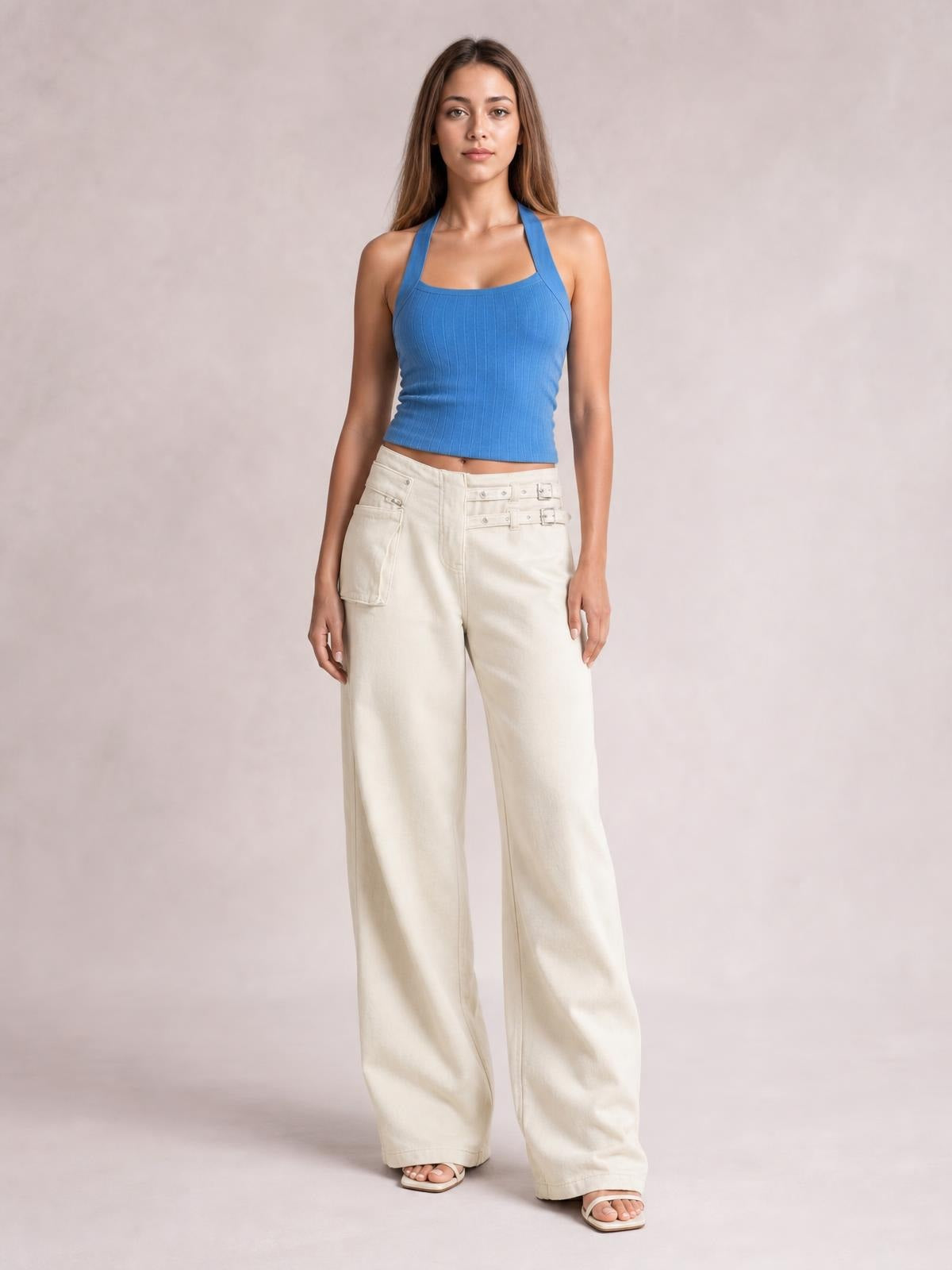 Model stands facing forward in cream wide leg jeans with front pockets, a high waist, belt loops, button fastening, and a relaxed floor-length silhouette.
