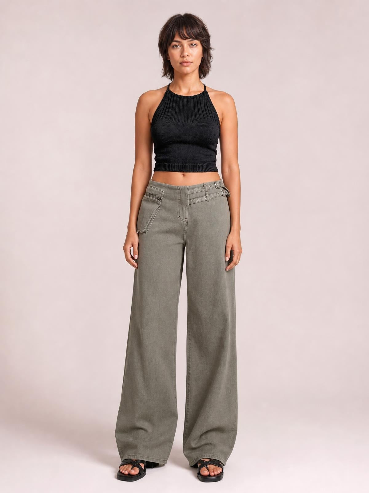 Model standing in gray wide-leg jeans with front and side pockets, a high-rise waistband, belt loops, zip fly, and relaxed full-length silhouette.