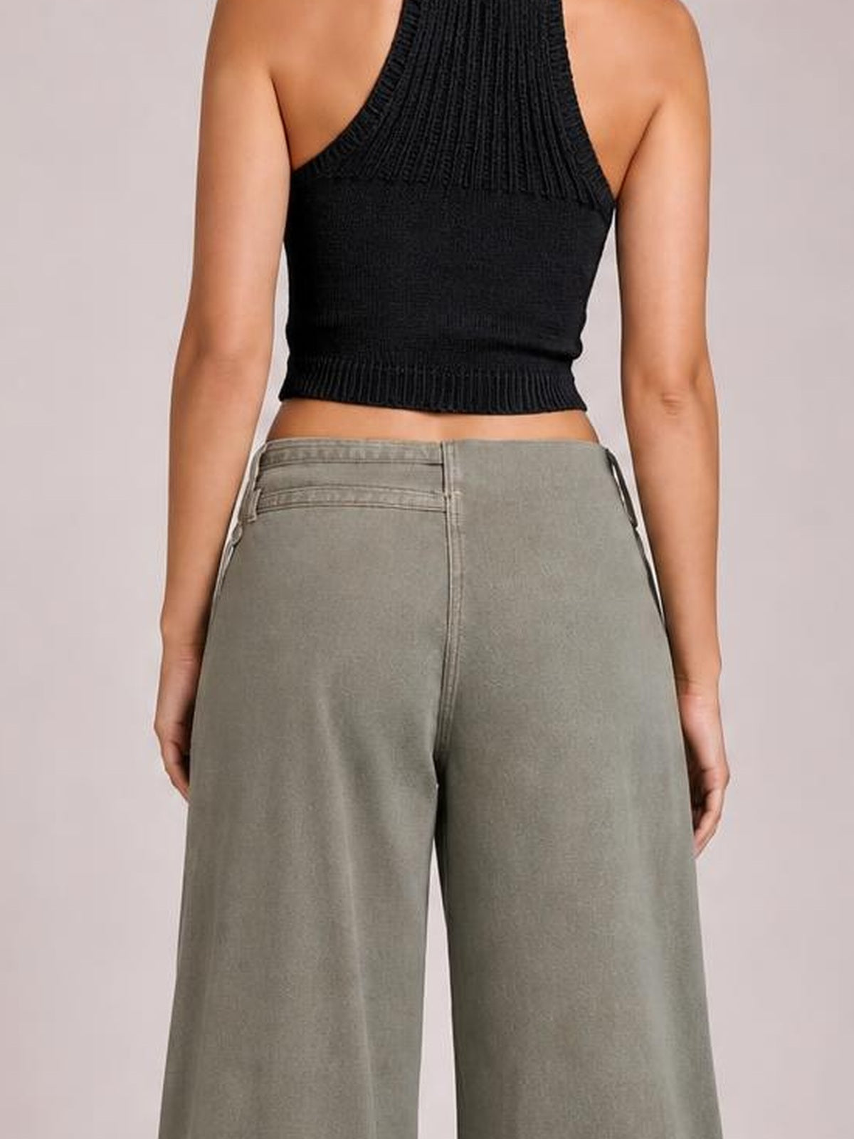 Model shown from behind wearing gray wide leg jeans with a structured waistband, visible back pockets, center seam, and relaxed full-length silhouette.