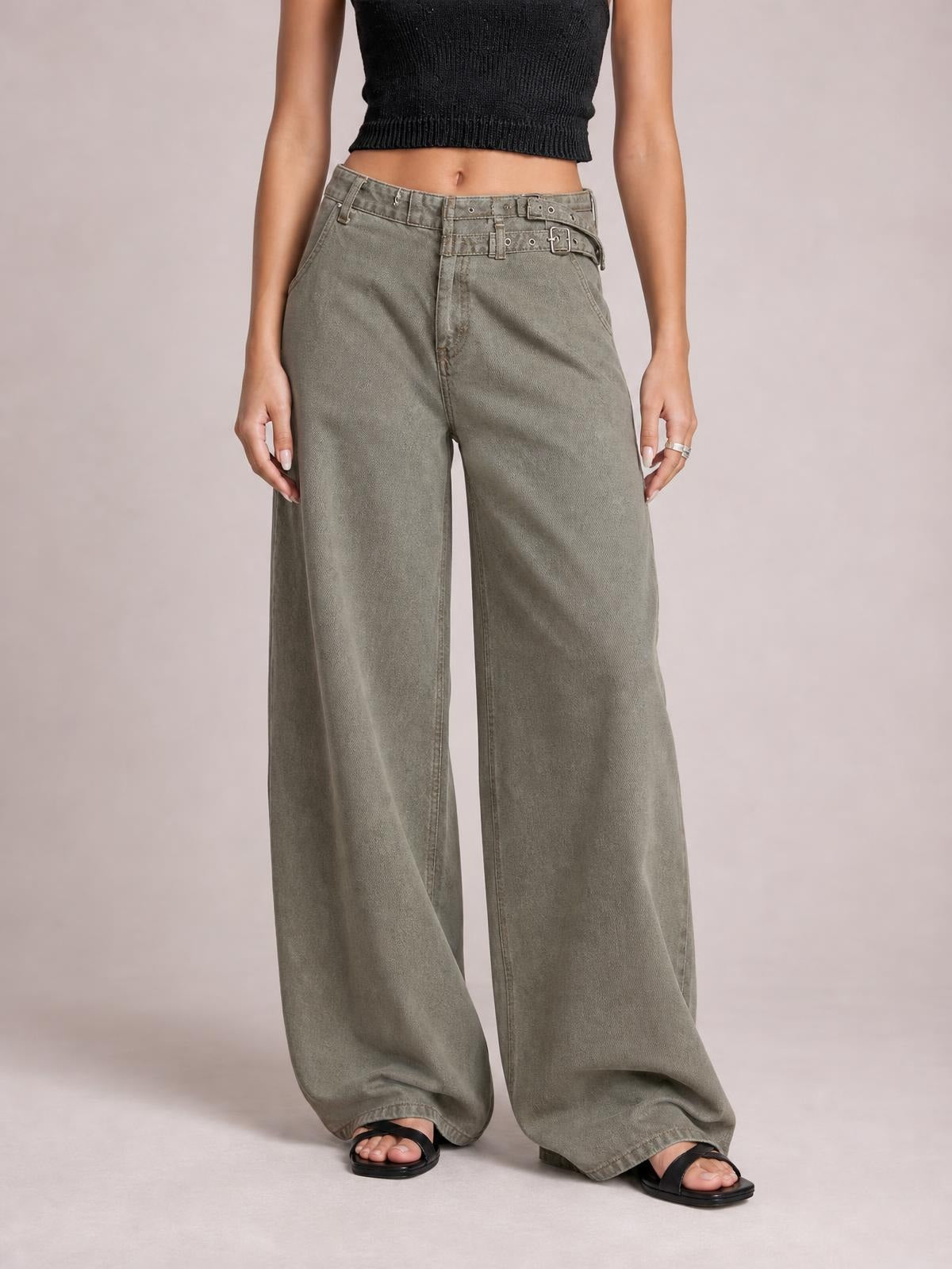Model wearing gray wide leg jeans with front pockets, a high-rise waistband, belt loops, zip fly, and a double-buckle belt detail.