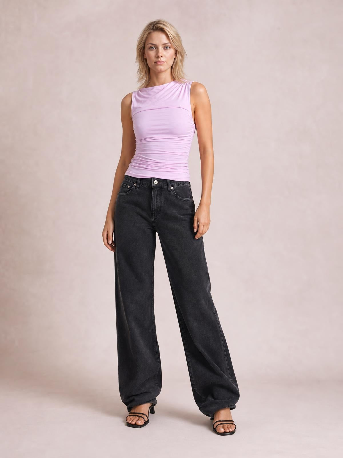 Model standing in dark charcoal wide leg jeans with front pockets, button closure, and a relaxed full-length silhouette.
