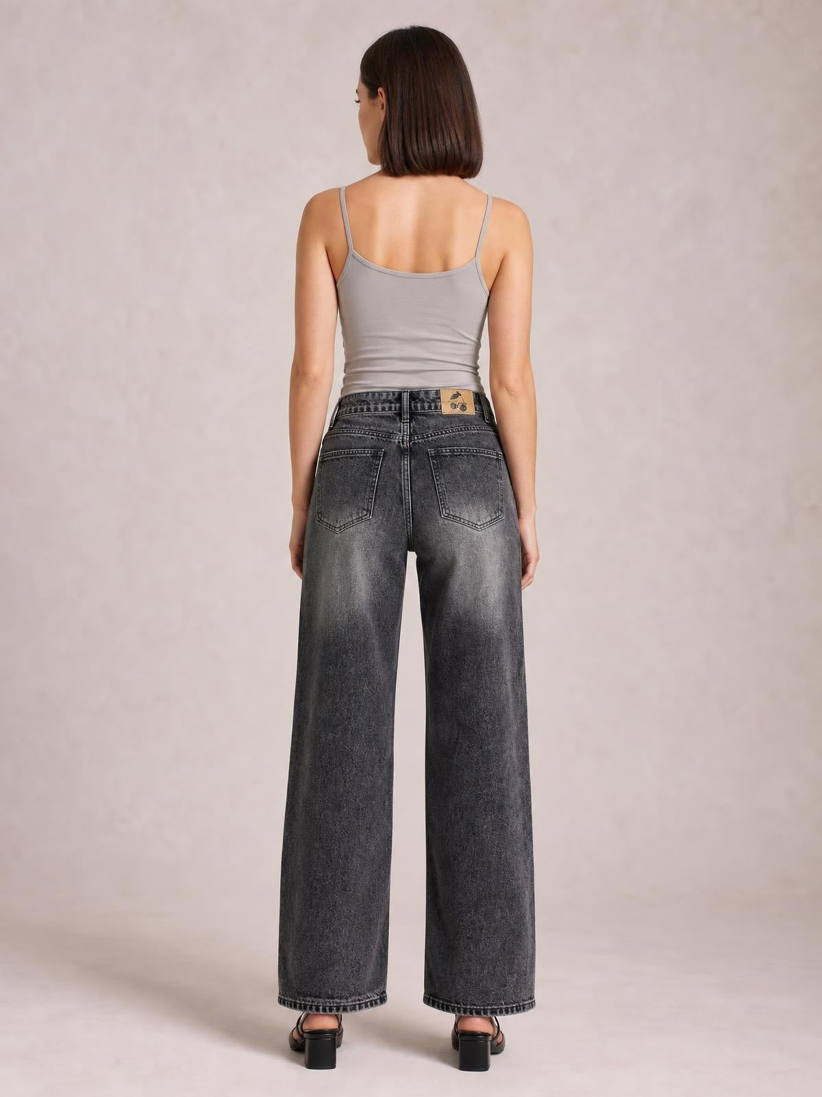 Model shown from the back wearing dark gray wide-leg jeans with back pockets, a buttoned waist, and a relaxed straight silhouette.