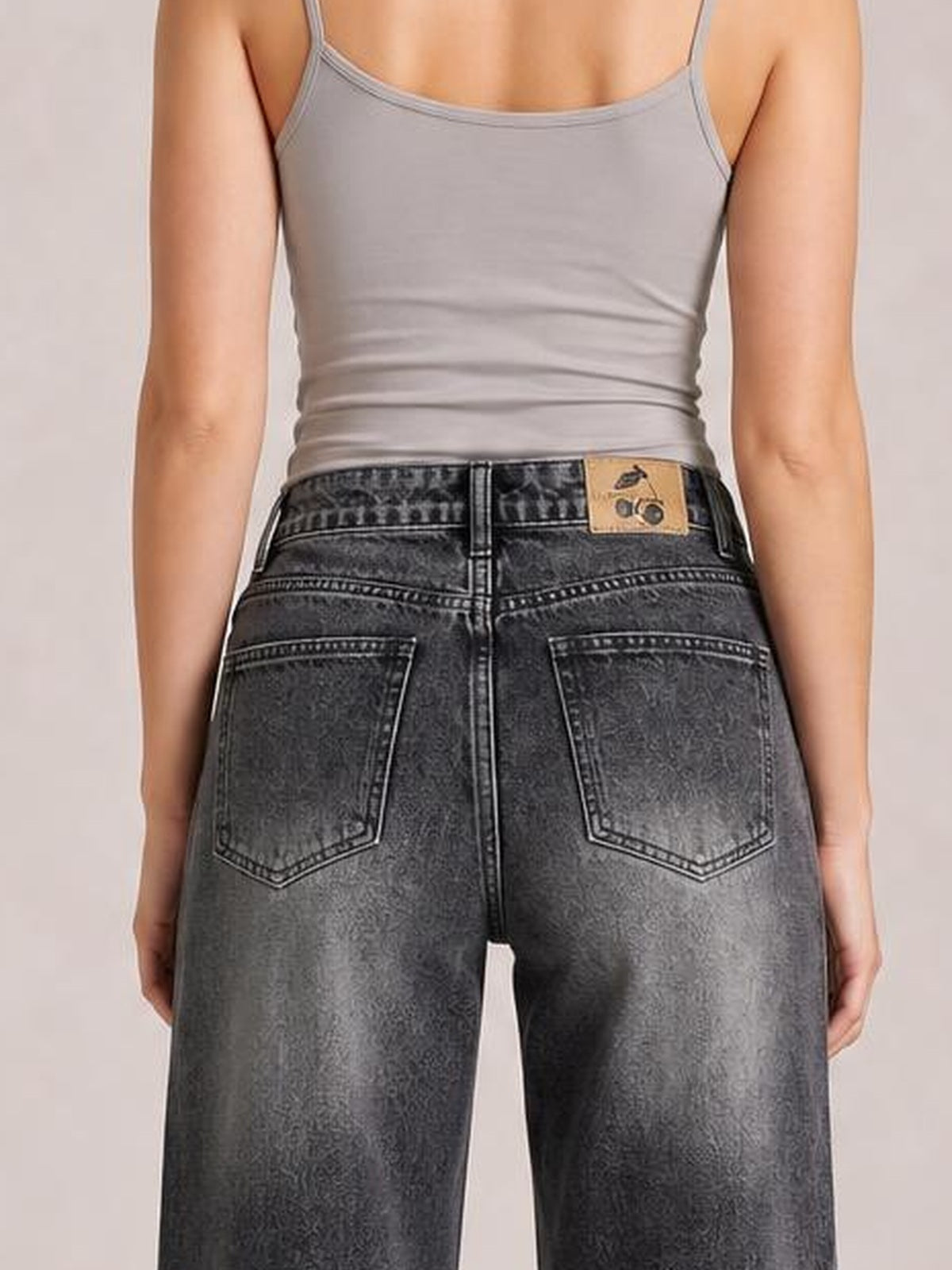 Model shown from behind wearing dark gray wide-leg jeans with a high-rise waistband, belt loops, contrasting stitching, and two back patch pockets.