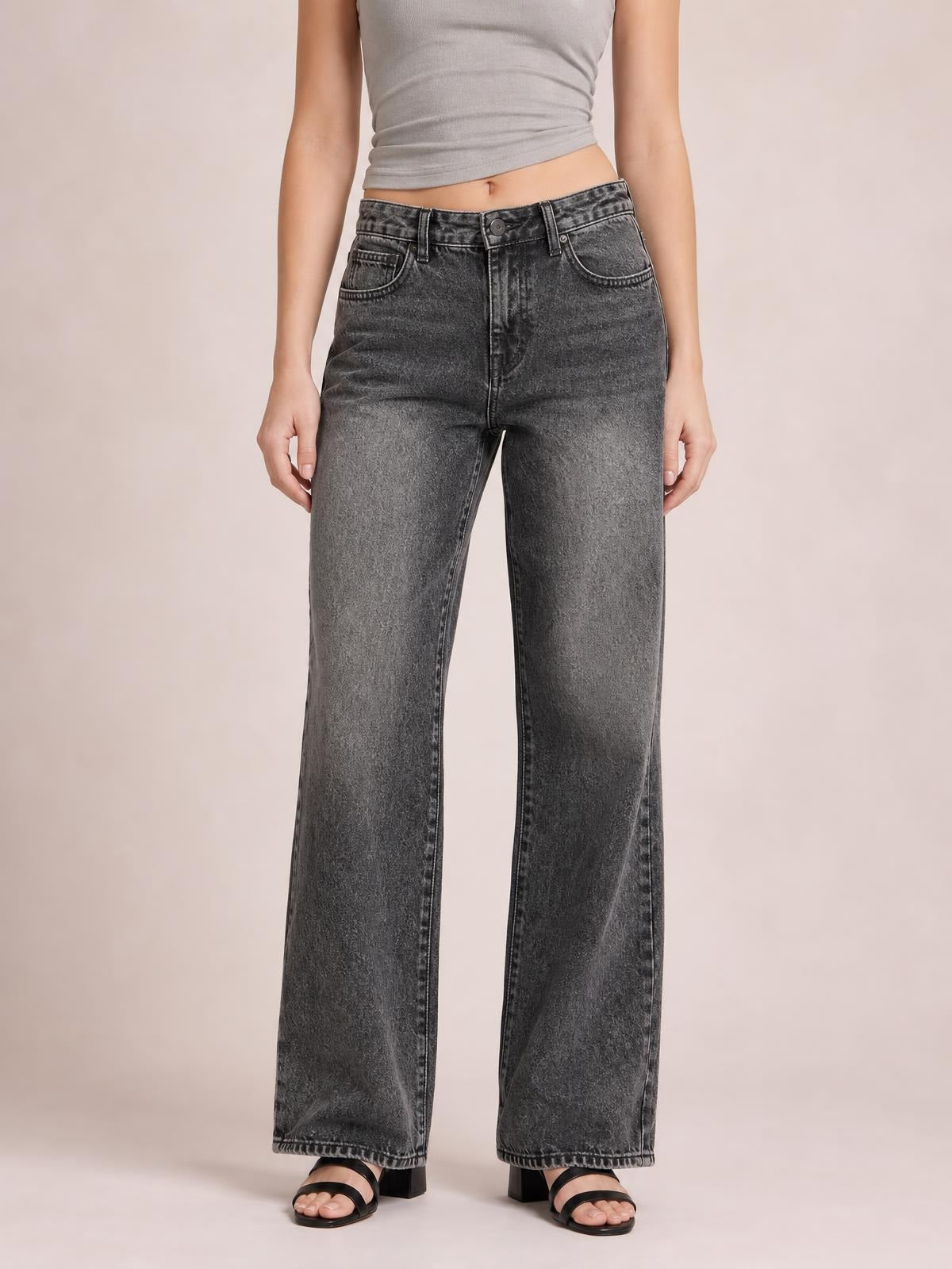 Model standing in gray wide-leg jeans with front pockets, belt loops, button closure, contrast stitching, and full-length straight hems.