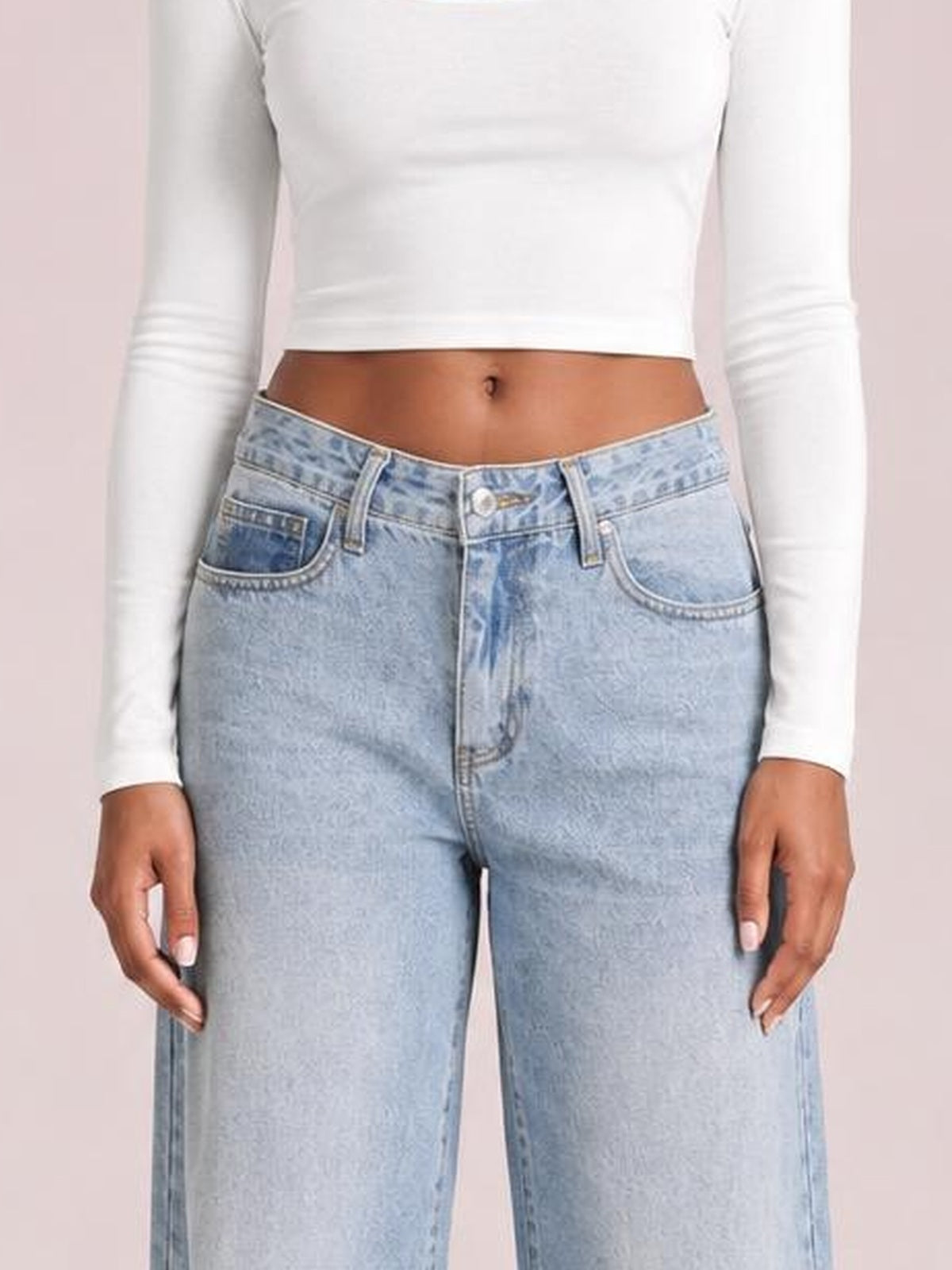 A model stands with hands at her sides wearing light blue wide leg jeans with front pockets, belt loops, contrast stitching, and a button fly.