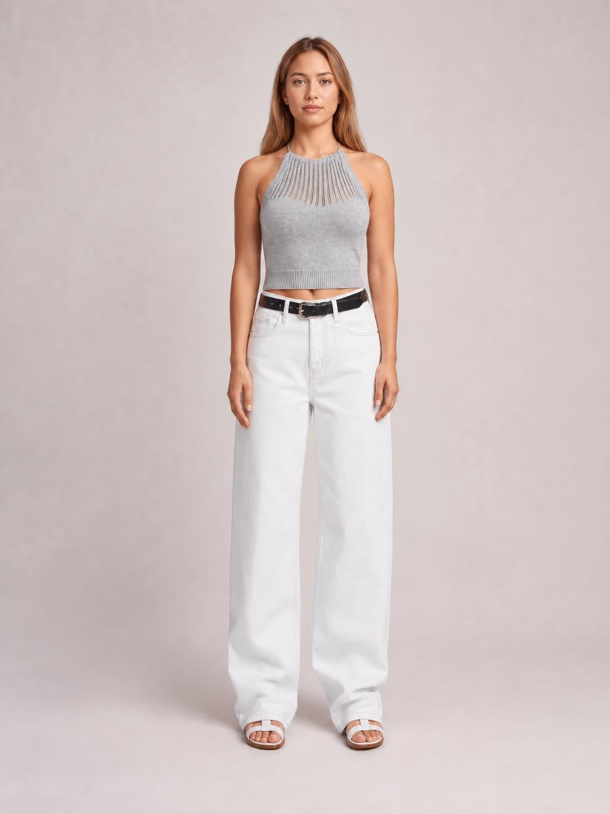 Model standing in white wide-leg jeans with front pockets, belt loops, and a buttoned high-rise waistband, creating a relaxed full-length silhouette.