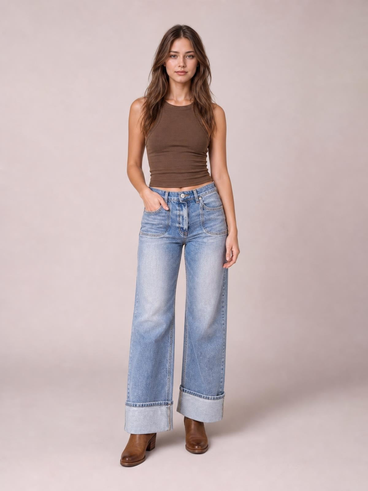 Model wearing light blue wide-leg wash jeans with front pockets, a button fly, cuffed hems, and a relaxed full-length silhouette.