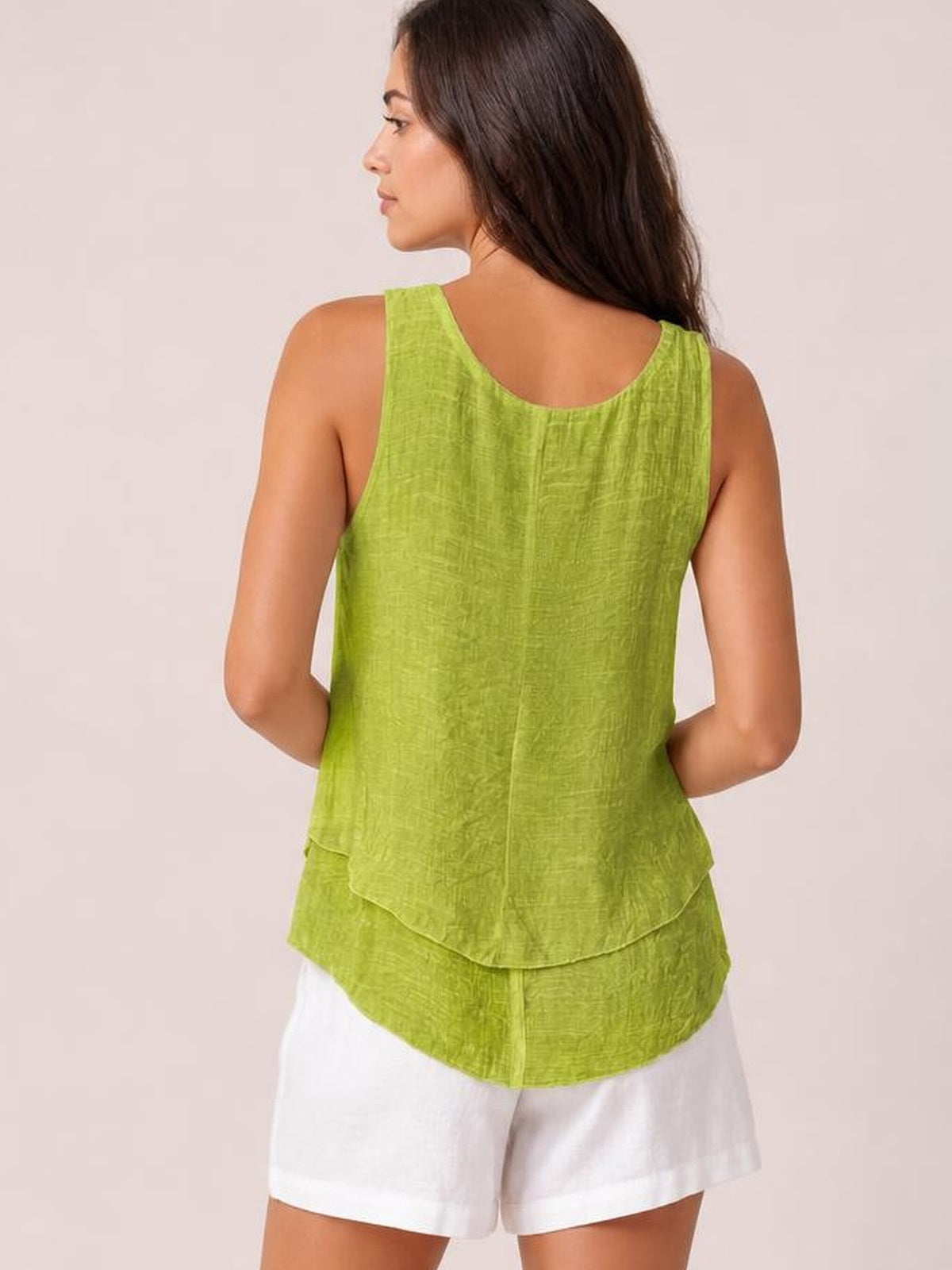 A model poses from the back in a lime green sheer layered tank with wide straps, a scoop neckline, relaxed silhouette, and tiered curved hem.