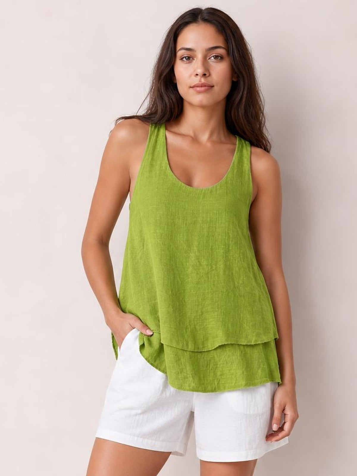 Model wears a lime green sheer layered tank with wide straps, a scoop neckline, relaxed flowy silhouette, and tiered hem over white shorts.