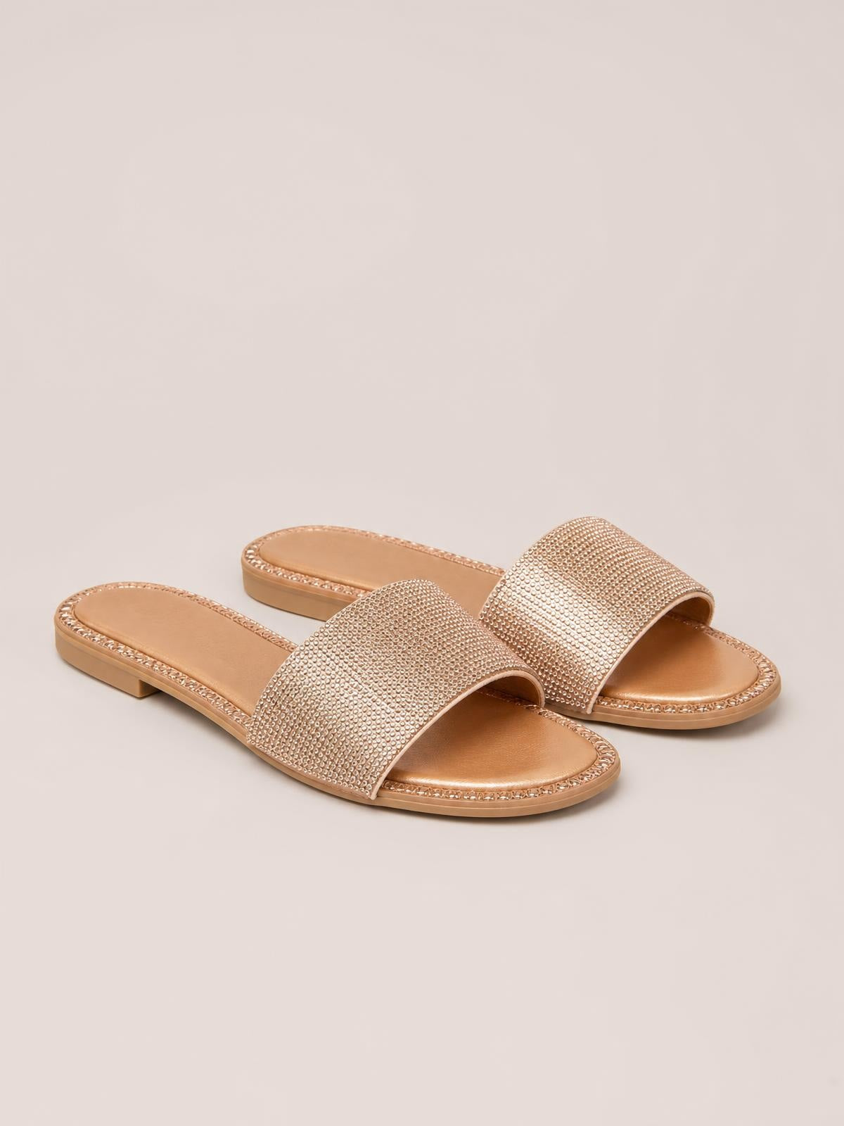 Champagne Rhinestone Open Toe Flat Sandals feature wide sparkling straps, cushioned footbeds, decorative trim, and low heels in a sleek slip-on silhouette.