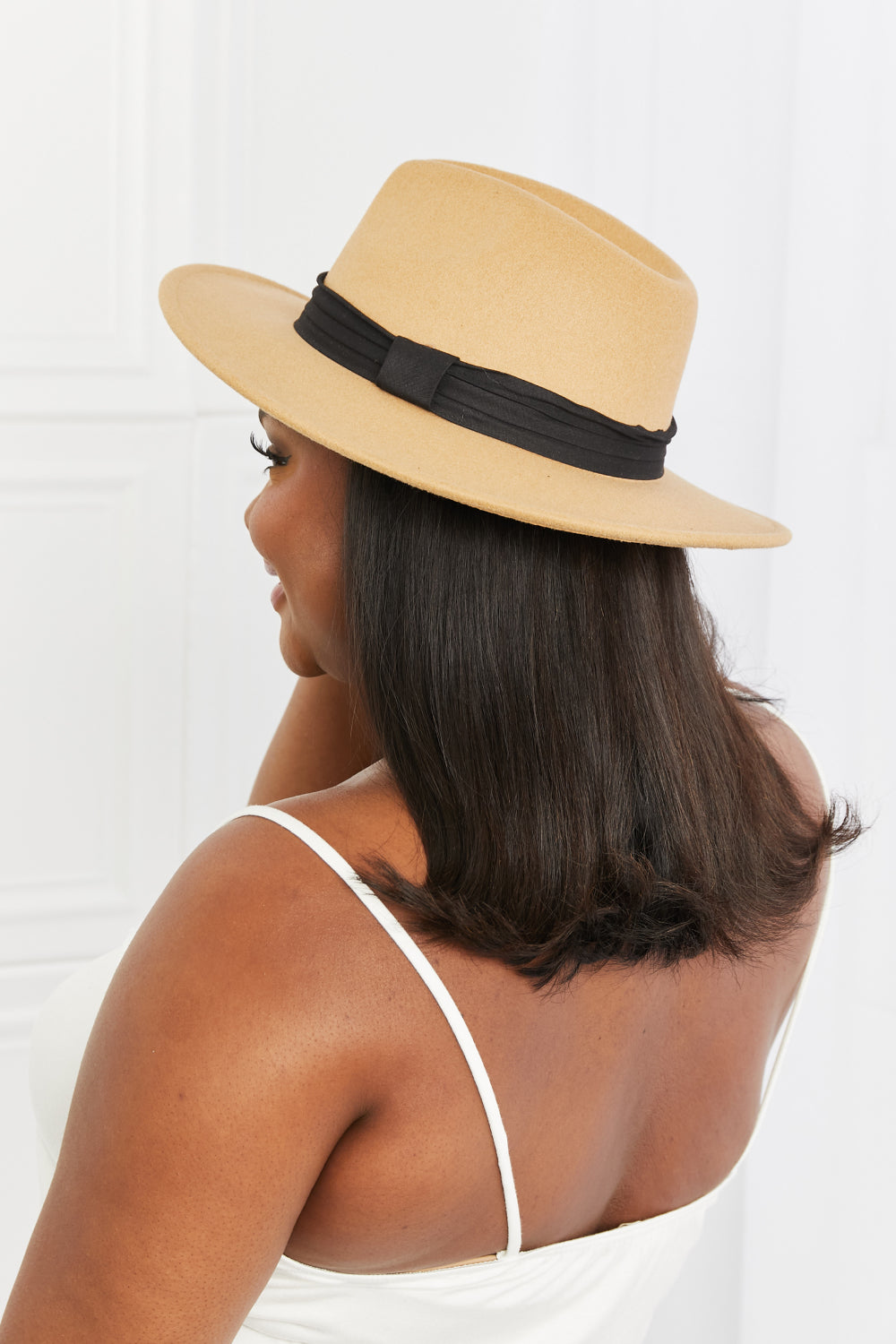 Model in profile wears a khaki You Got It fedora hat with a softly shaped crown, wide brim, and contrasting black ribbon band.