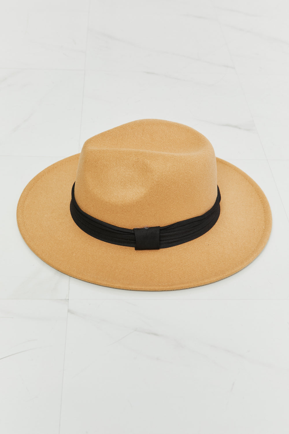 Khaki fedora hat with a softly shaped crown, wide brim, and contrasting black ribbon band with a centered buckle detail.