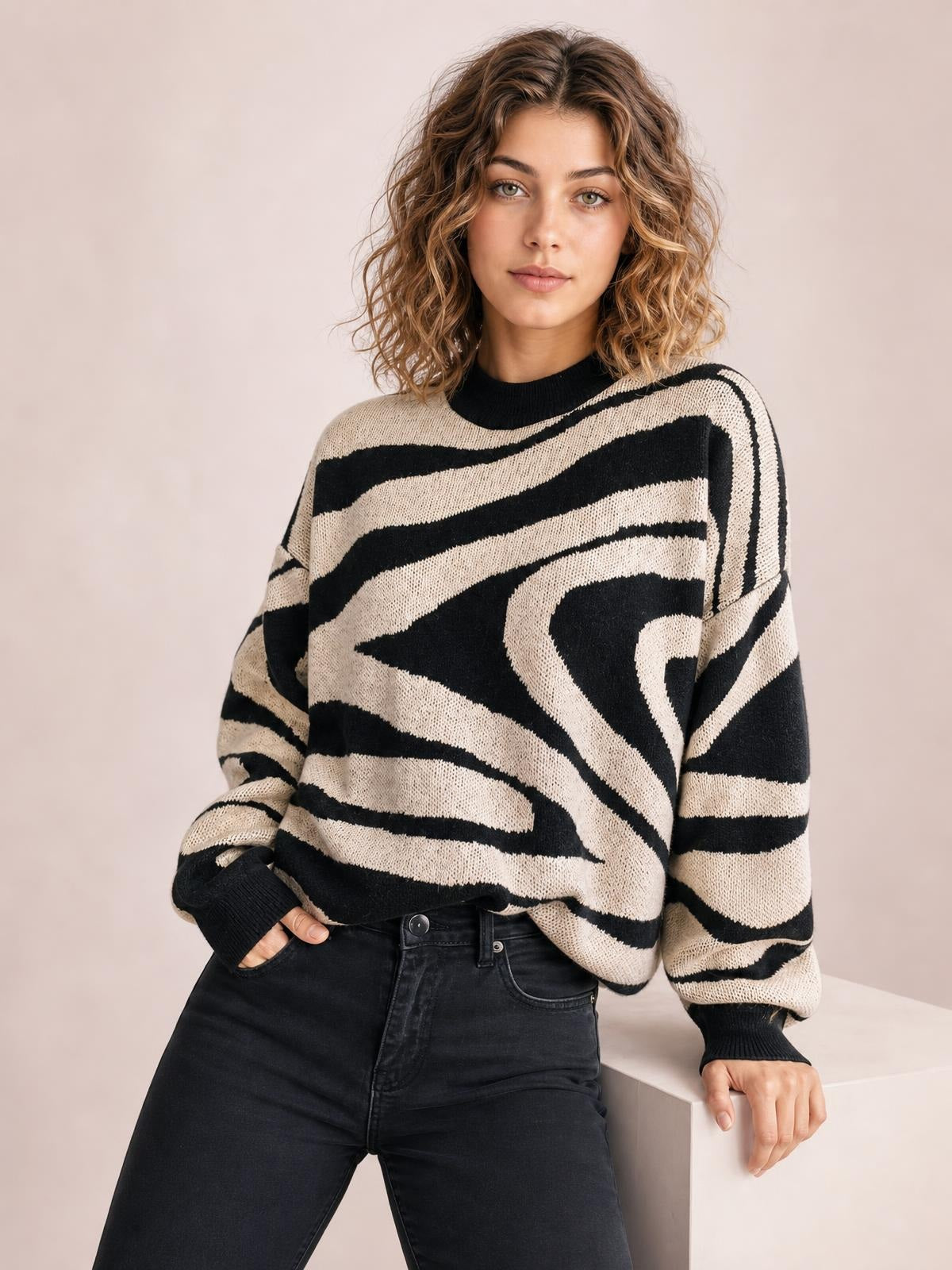 Model wearing an oversized black-and-cream zebra print round neck sweater with dropped shoulders, long sleeves, ribbed cuffs, and a relaxed silhouette.