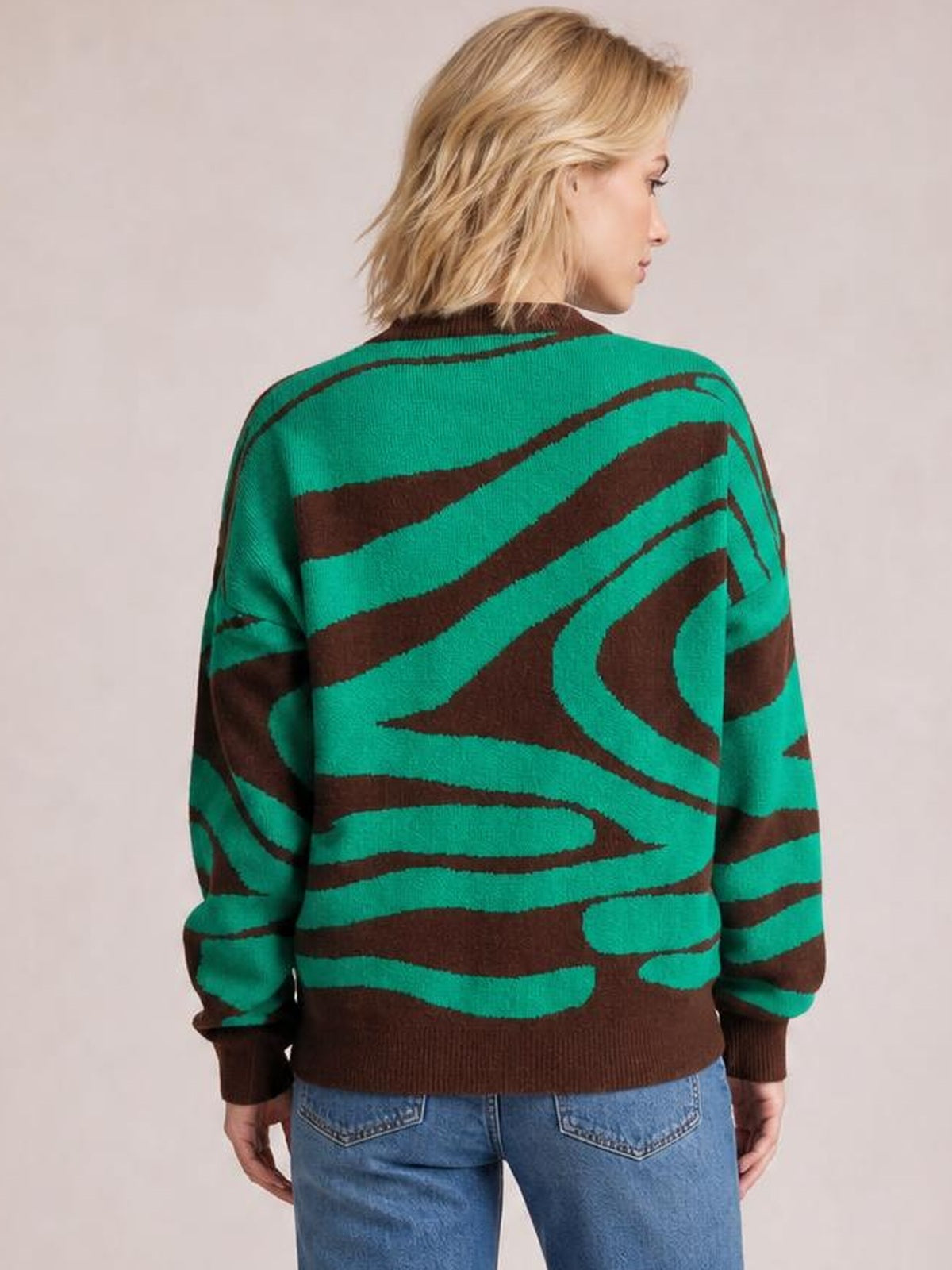 Model shown from the back in an oversized green and brown zebra print round neck sweater with long sleeves, ribbed cuffs, hem, and neckline.