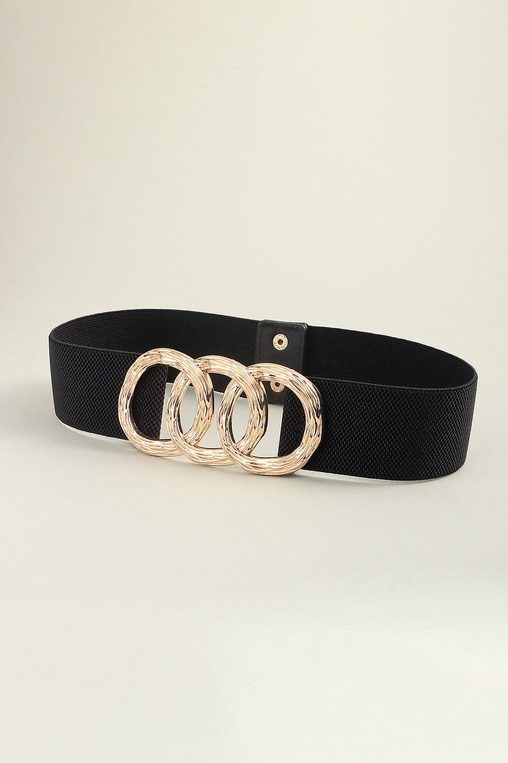 Black wide elastic belt with a structured silhouette and statement zinc alloy buckle featuring three interlocking gold-tone rings.